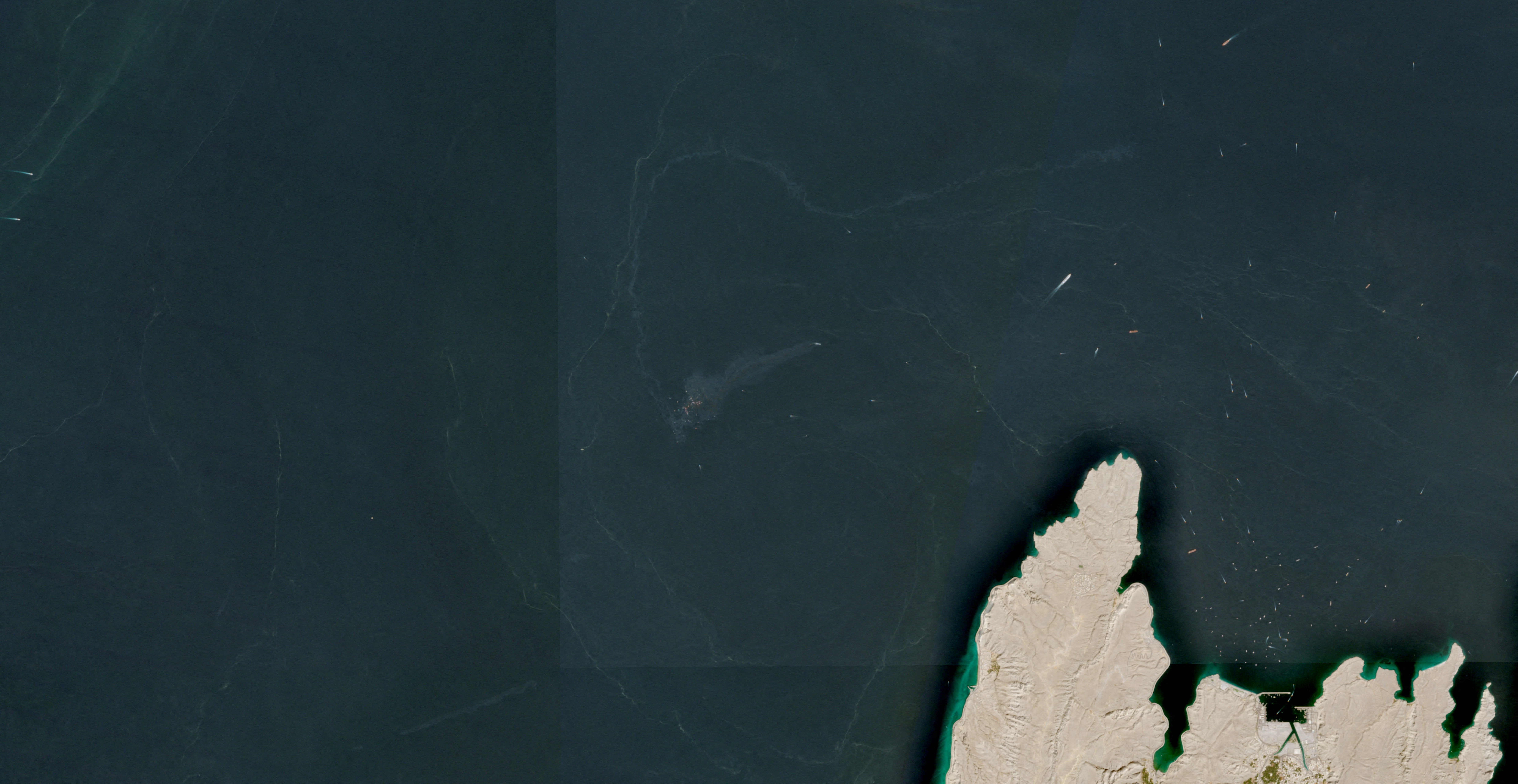 A satellite image shows containers and items floating in the water after a vessel sank near the Strait of Hormuz, off the coast of Oman, October 14, 2026