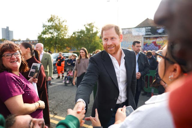 Prince Harry smiling and greeting well-wishers