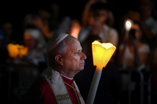 Pope Leo holds a candle as he takes part in a torchlight procession following the Rosary Prayer at the Shrine of Our Lady of Lourdes
