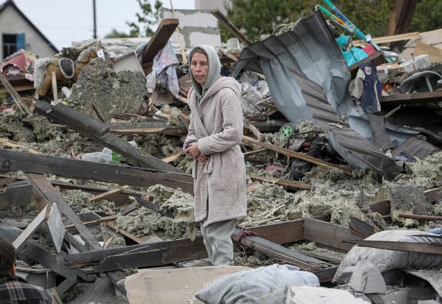 A woman stands at the site of her in-laws’ house, destroyed during a Russian airstrike on the outskirts of Dnipro on 15 October