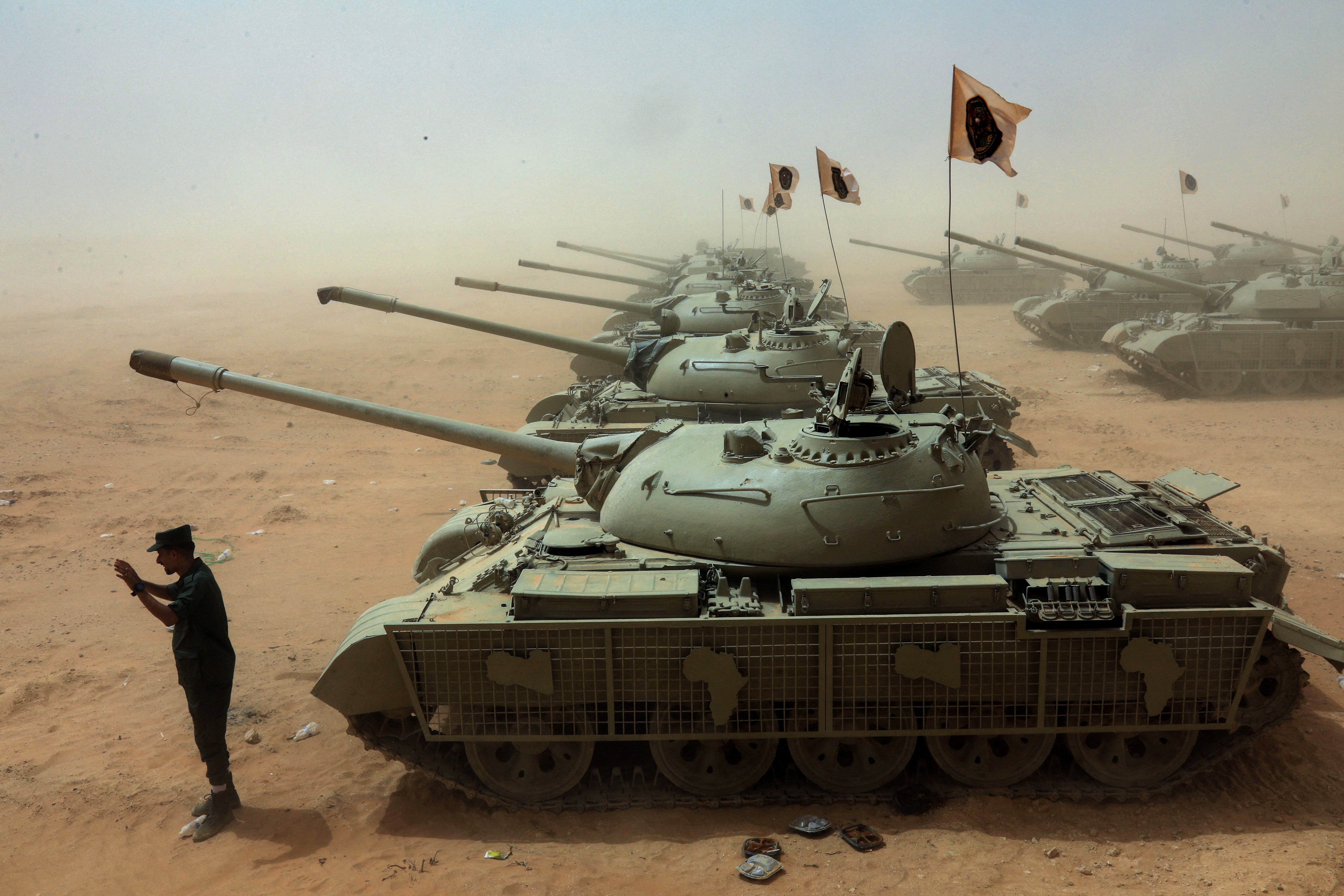 A Libyan soldier stands near tanks taking part in the "Dara' al-Karama 2" military exercises, conducted by the Libyan National Army (LNA)