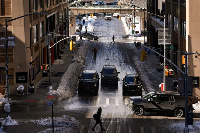 Pedestrians and cars pass through the Dumbo neighborhood of Brooklyn borough of New York, Feb. 24, 2026