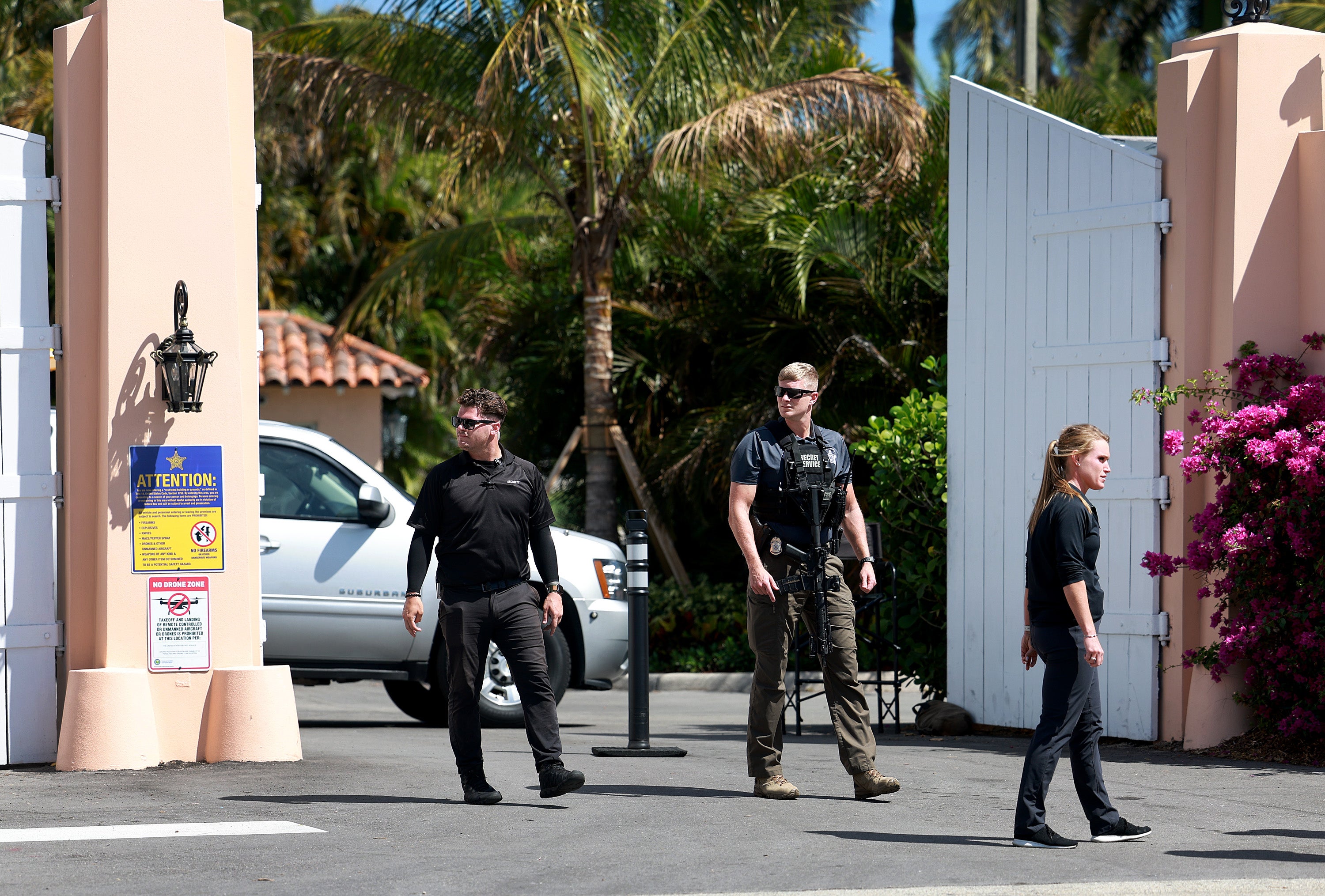 Security people along with a Secret Service agent stand at one of the entrances to former President Donald Trump's Mar-a-Lago home on March 23, 2023