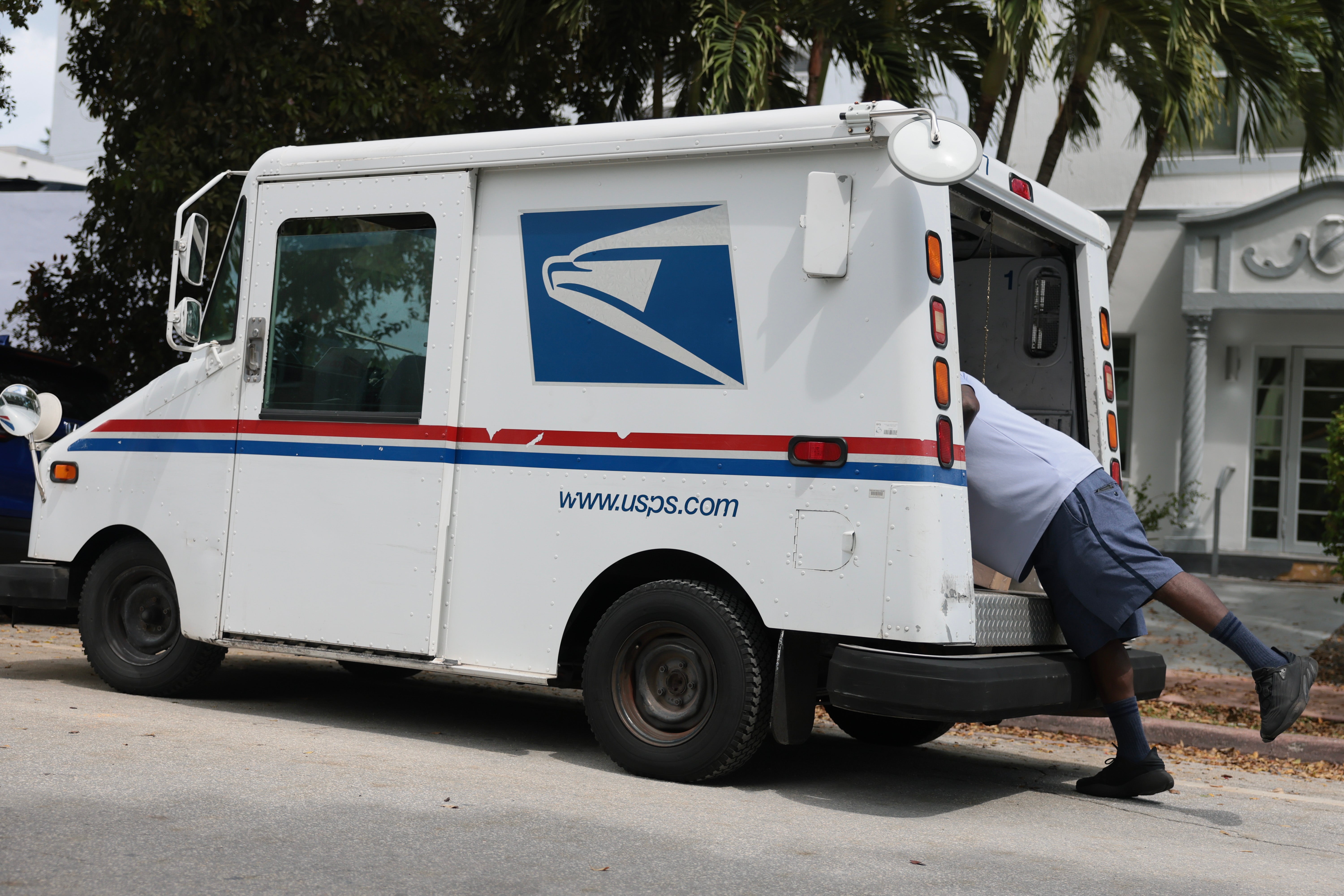 Postal carrier Marc Jacques delivers the mail in a neighborhood in Miami