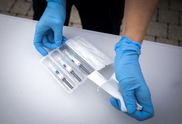 A nurse preparing flu vaccine jabs