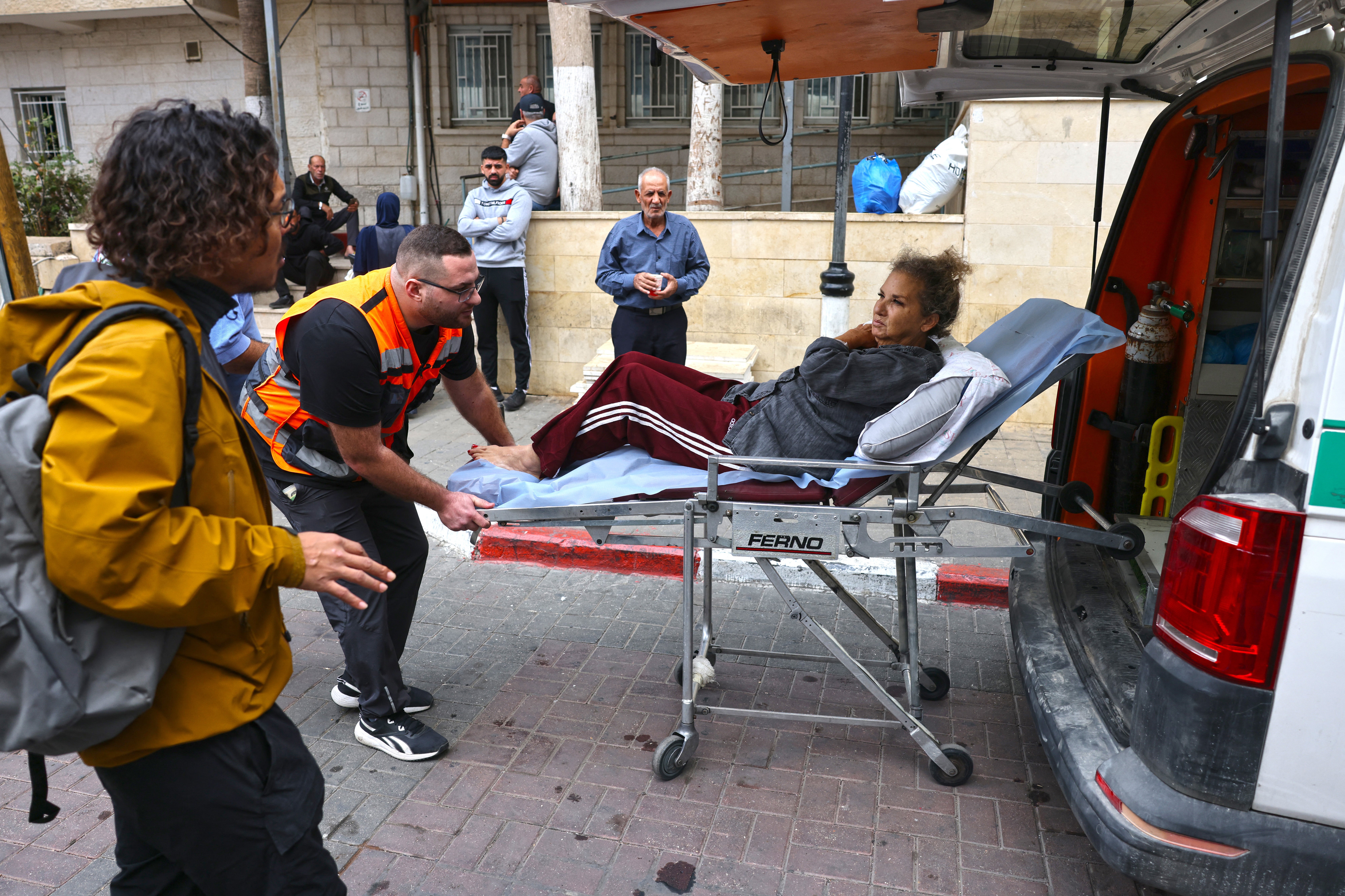 American freelance photojournalist Heidi Levine is transferred on a stretcher into a Palestinian ambulance from the government hospital in the Israeli-occupied city of Ramallah before she is handed over to an Israeli ambulance at a checkpoint for onward transport to a hospital in Tel Aviv