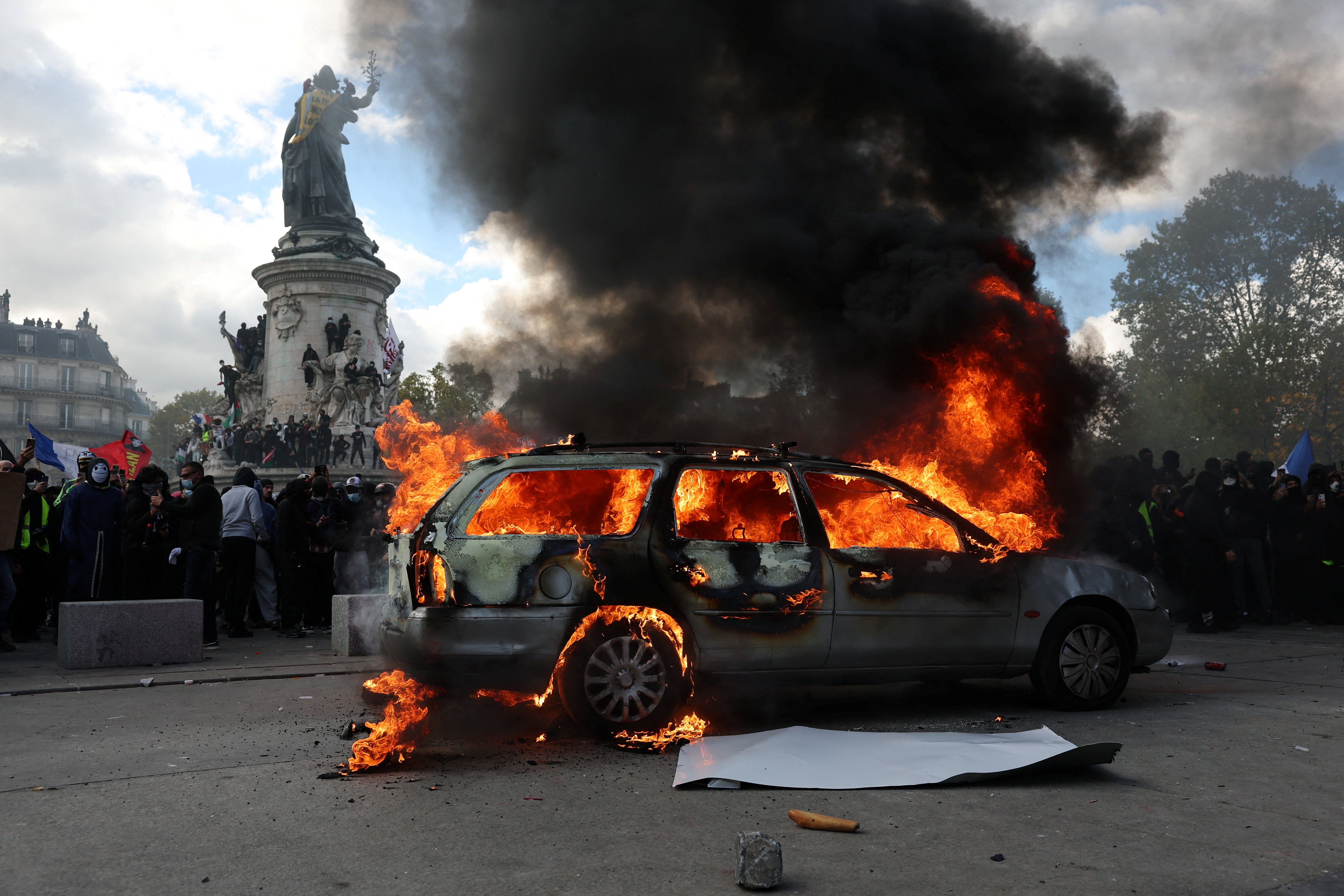 A car burns amid clashes between protesters and the French police during a demonstration