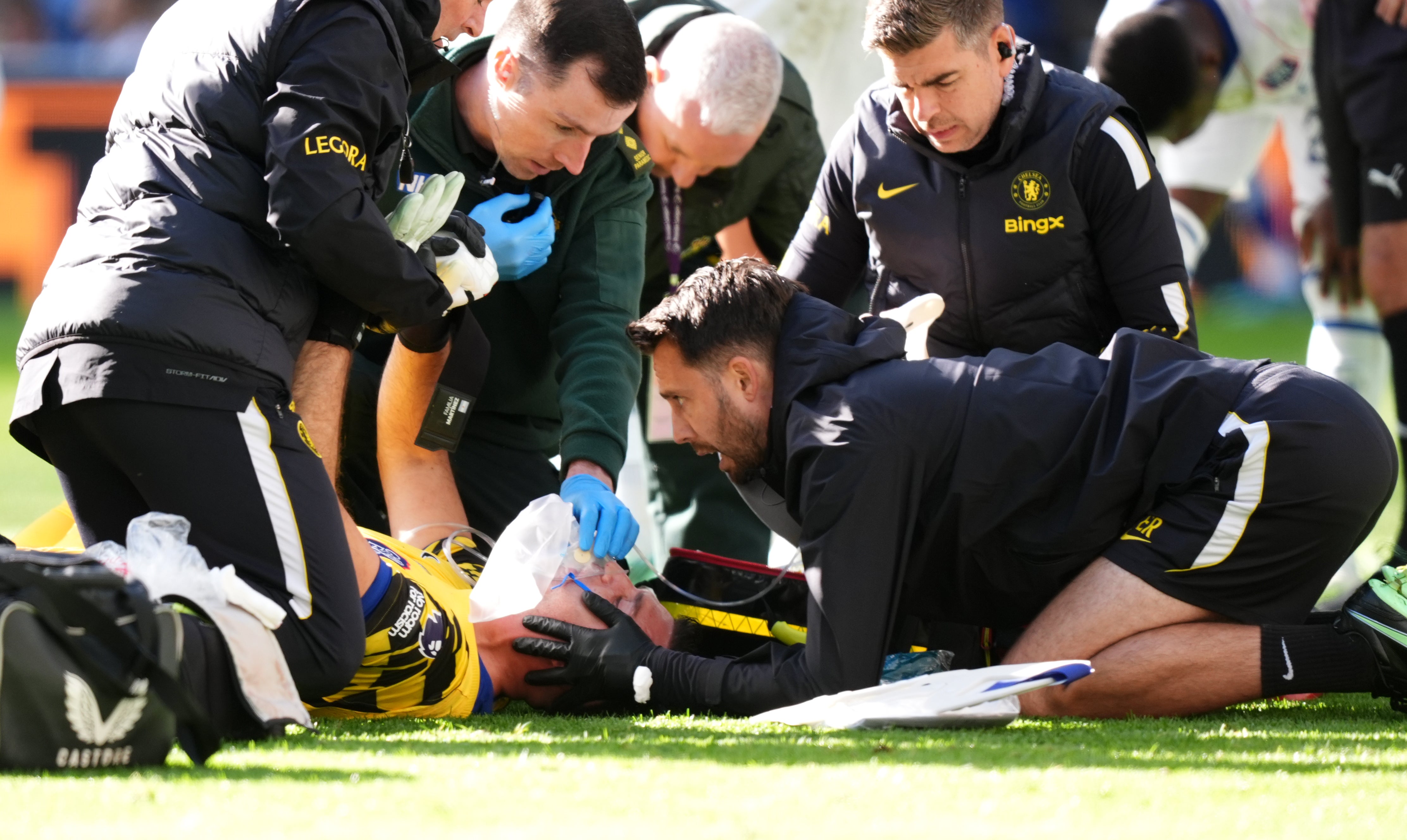 Chelsea goalkeeper Emiliano Martinez receives oxygen as physios work with caution
