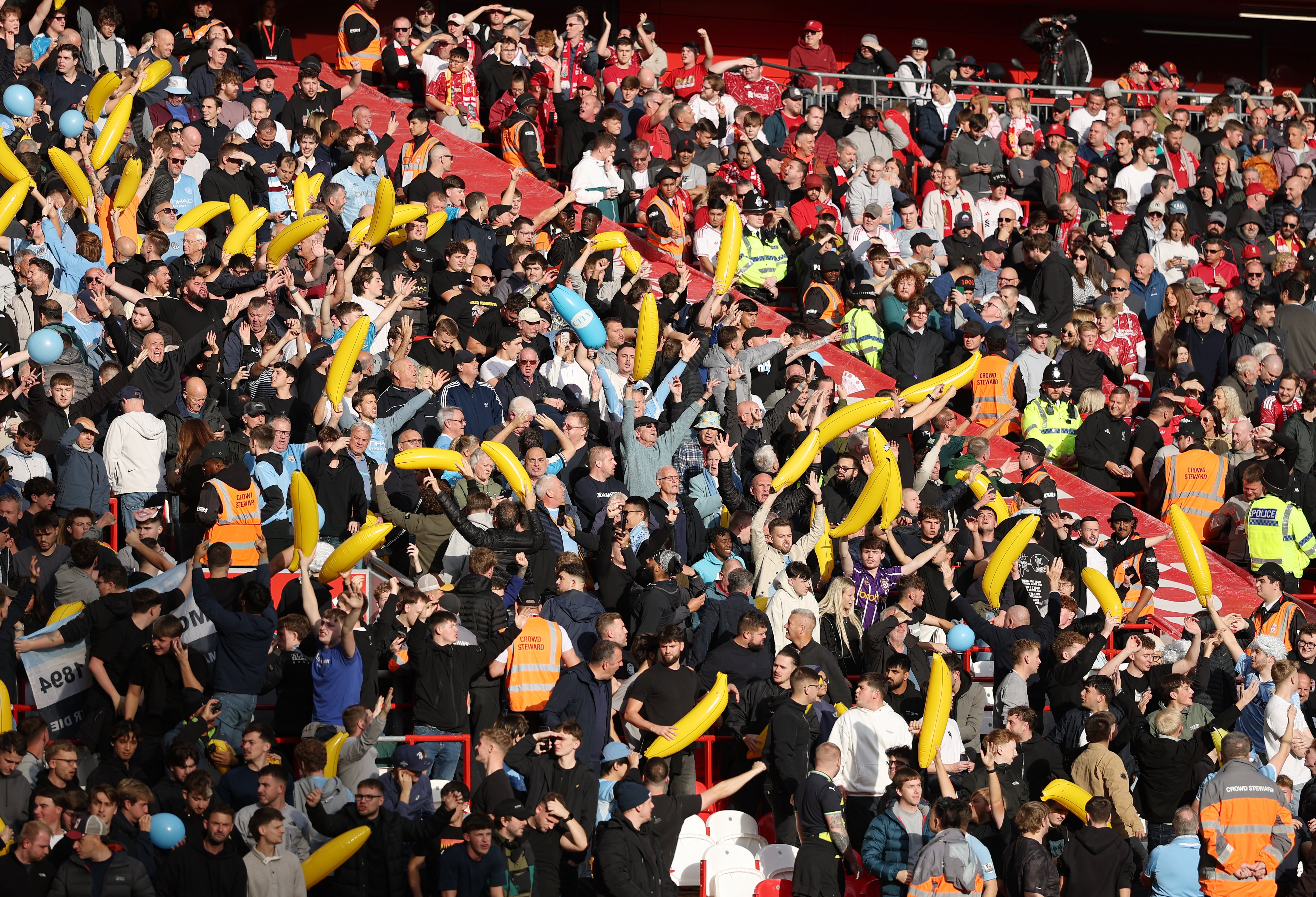 Manchester City fans hold up inflatable bananas towards Liverpool fans