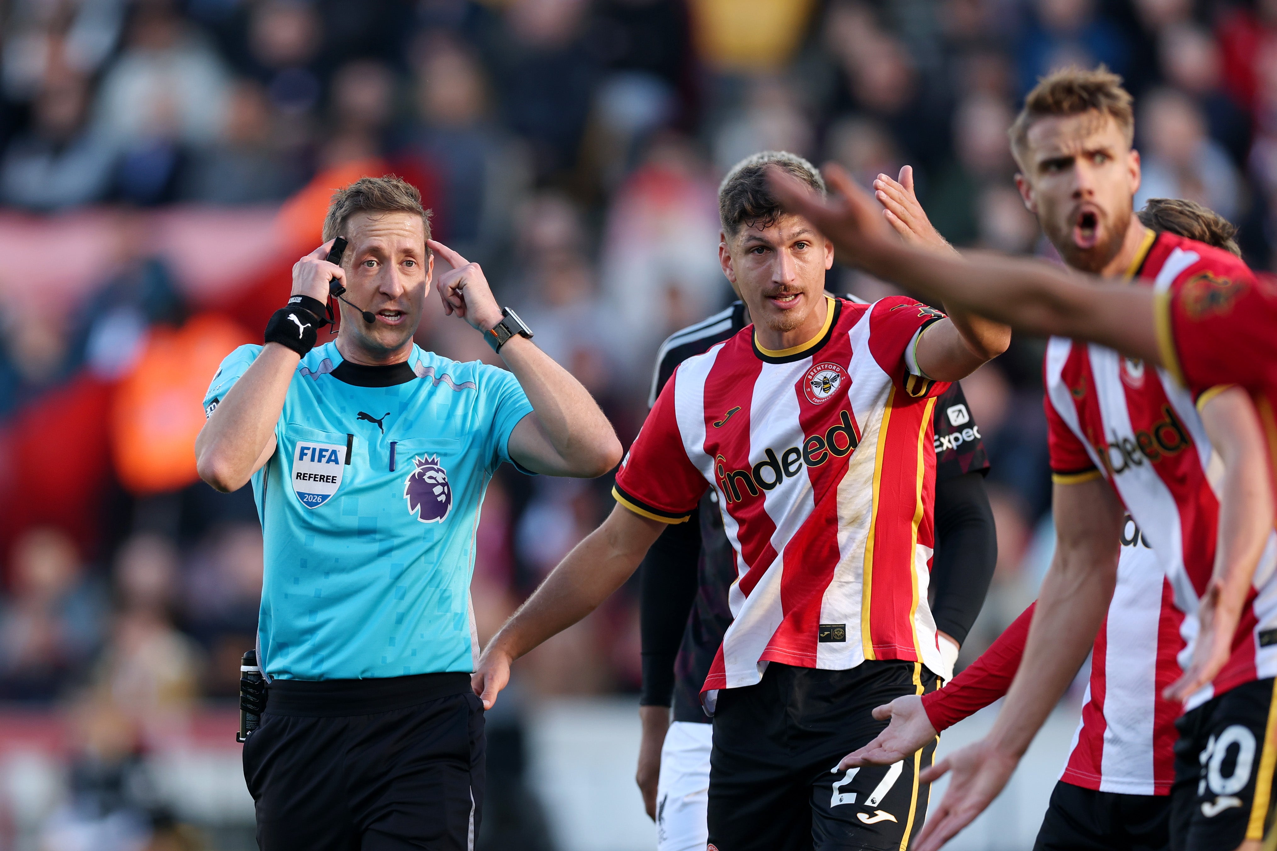 Referee John Brooks gestures to his head before showing a red card to Yehor Yarmolyuk of Brentford
