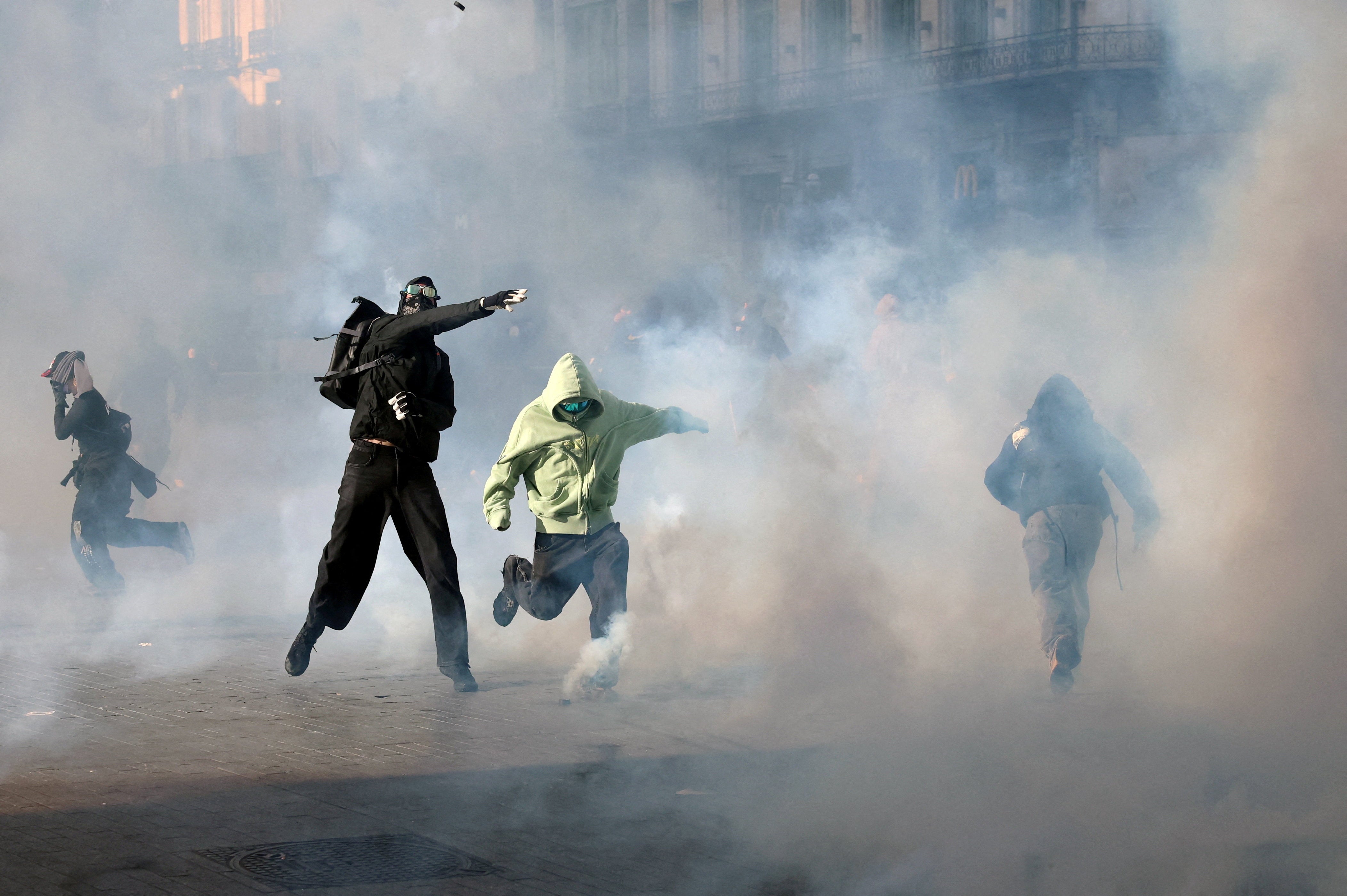 Demonstrators react to tear gas fir