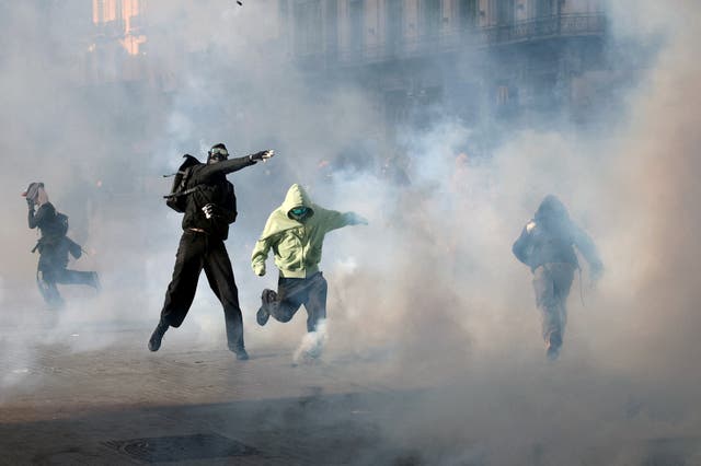 Demonstrators react to tear gas fired by police during a students' protest in Brussels, Belgium
