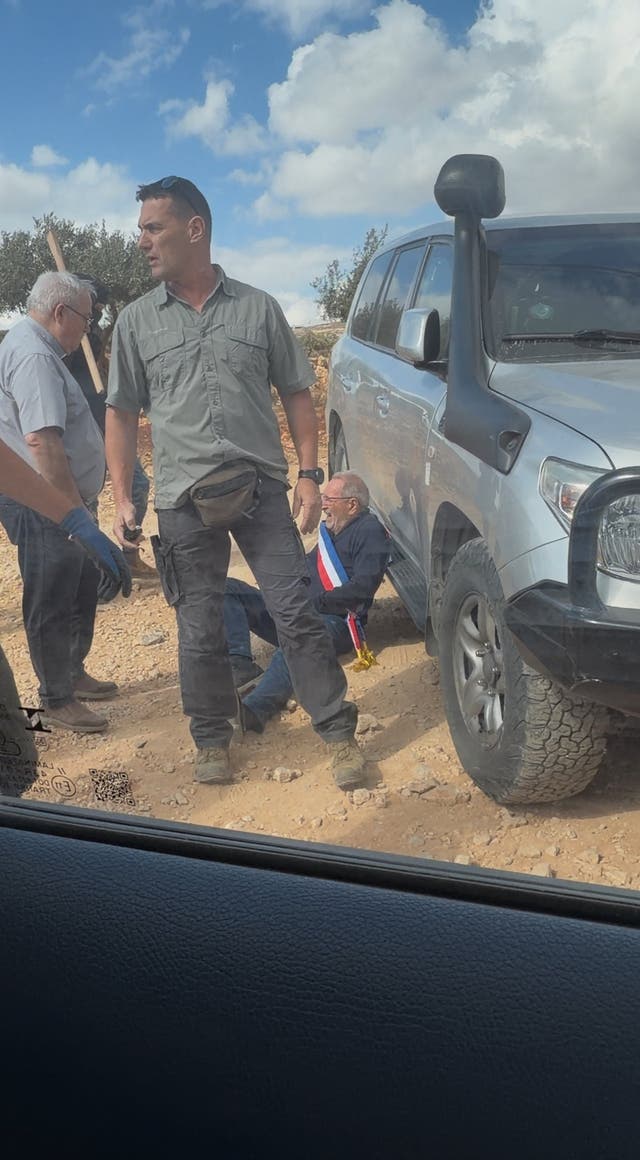 A man reacts on the ground where Belgium's foreign minister says settlers attacked Palestinians, Catholic representatives and Western diplomats and officials, in Taybeh, in the Israeli-occupied West Bank