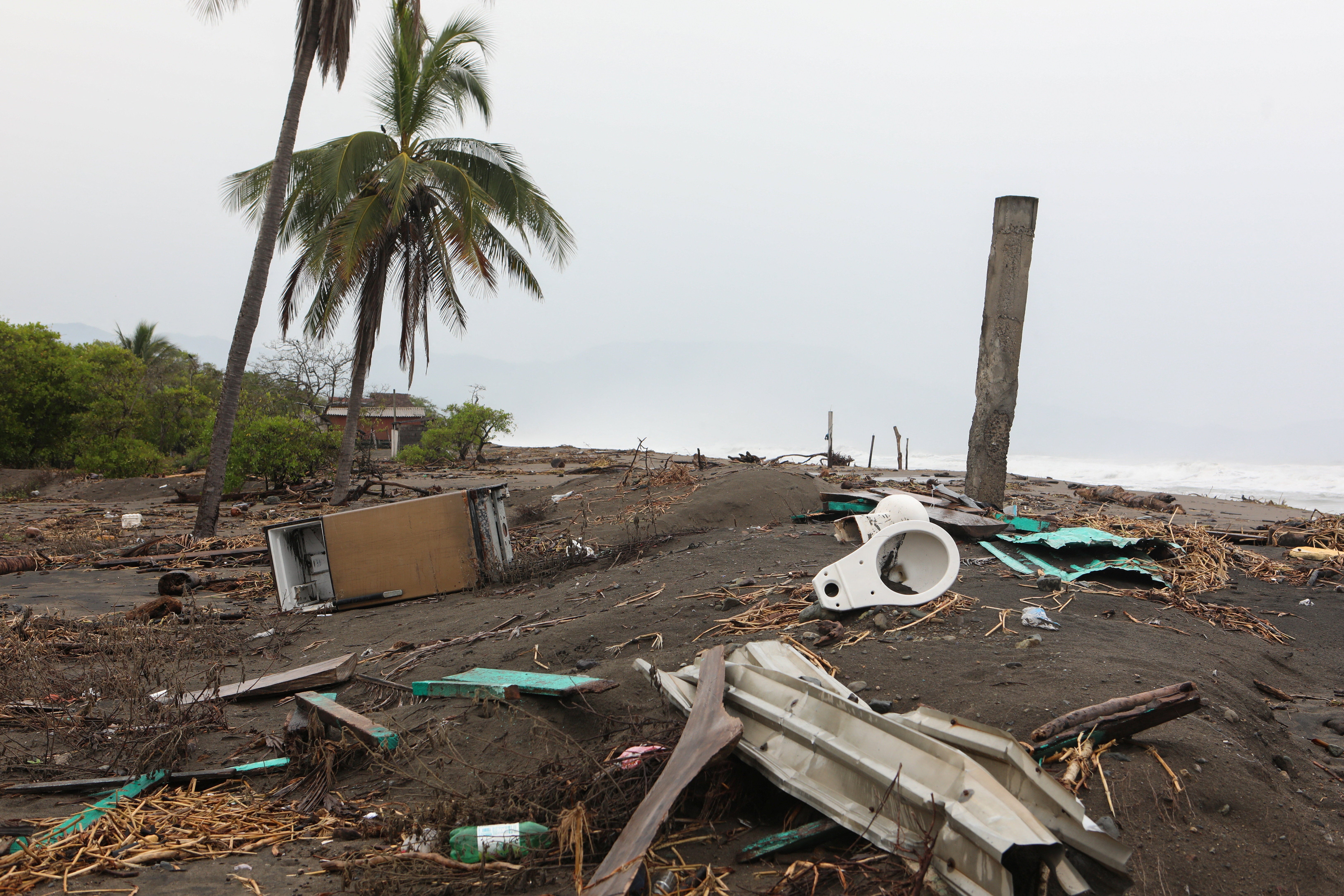 Debris lies on a beach as Hurricane Trudy advances across the Pacific Ocean off Mexico's western coast