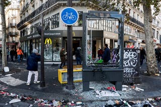 People walk past the damaged window of a McDonald's in Paris