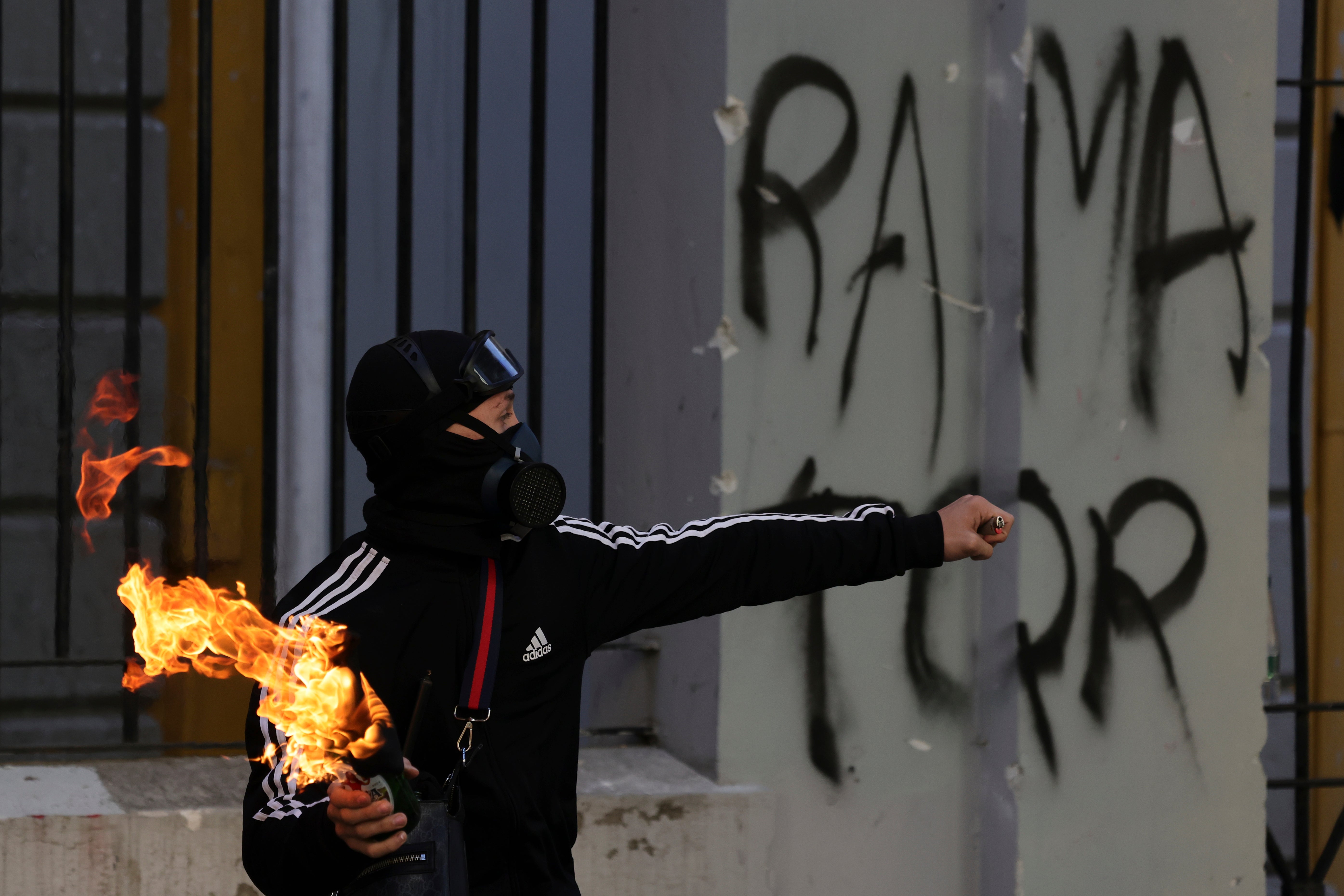 A protester prepares to throw a petrol bomb toward riot police during clashes at an anti-government demonstration in Tirana, Albania, Sunday, Oct. 18, 2026