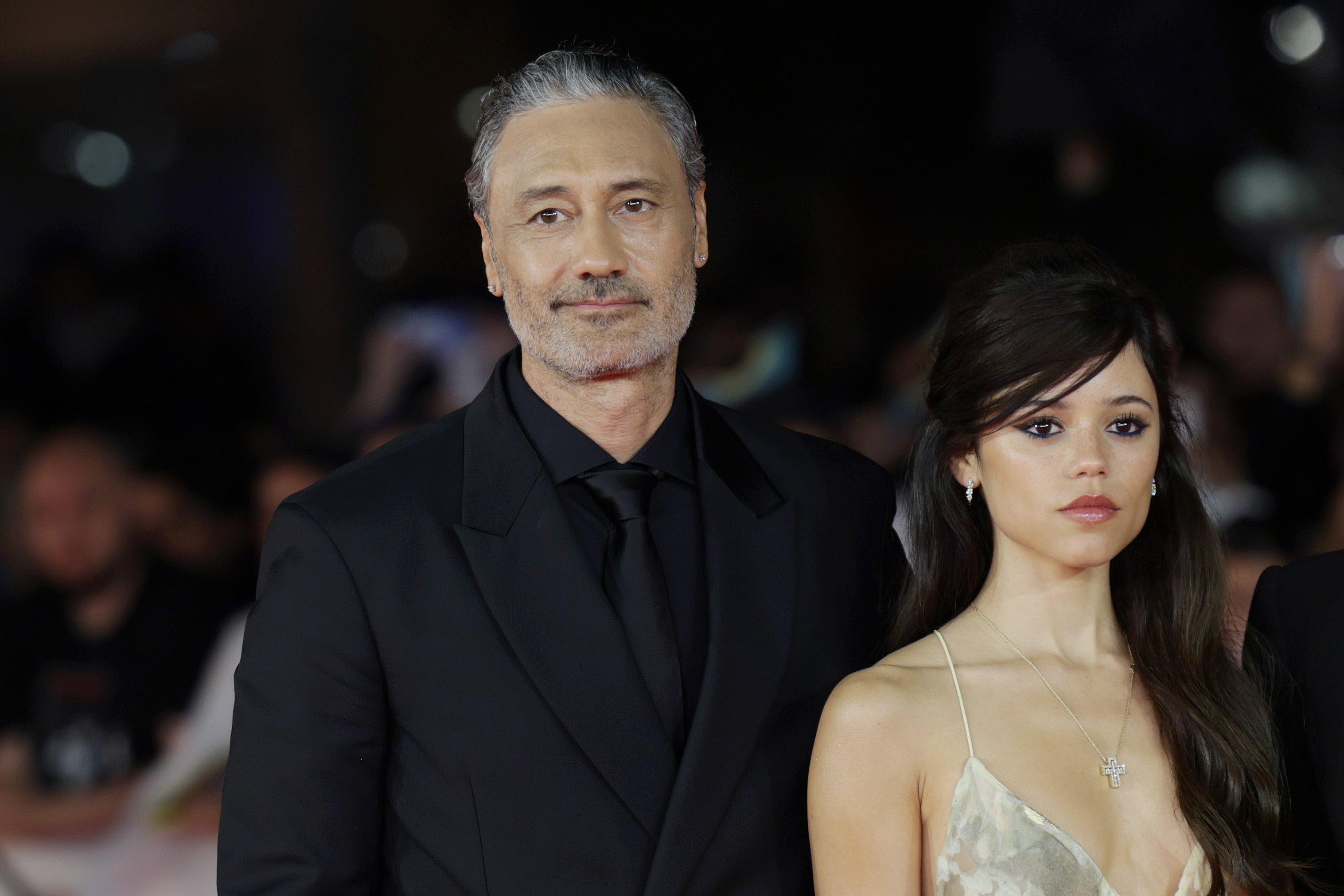 Taika Waititi, left, is promoting Klara and the Sun , starring Jenna Ortega, right, his film adaptation of the 2021 novel by Kazuo Ishiguro