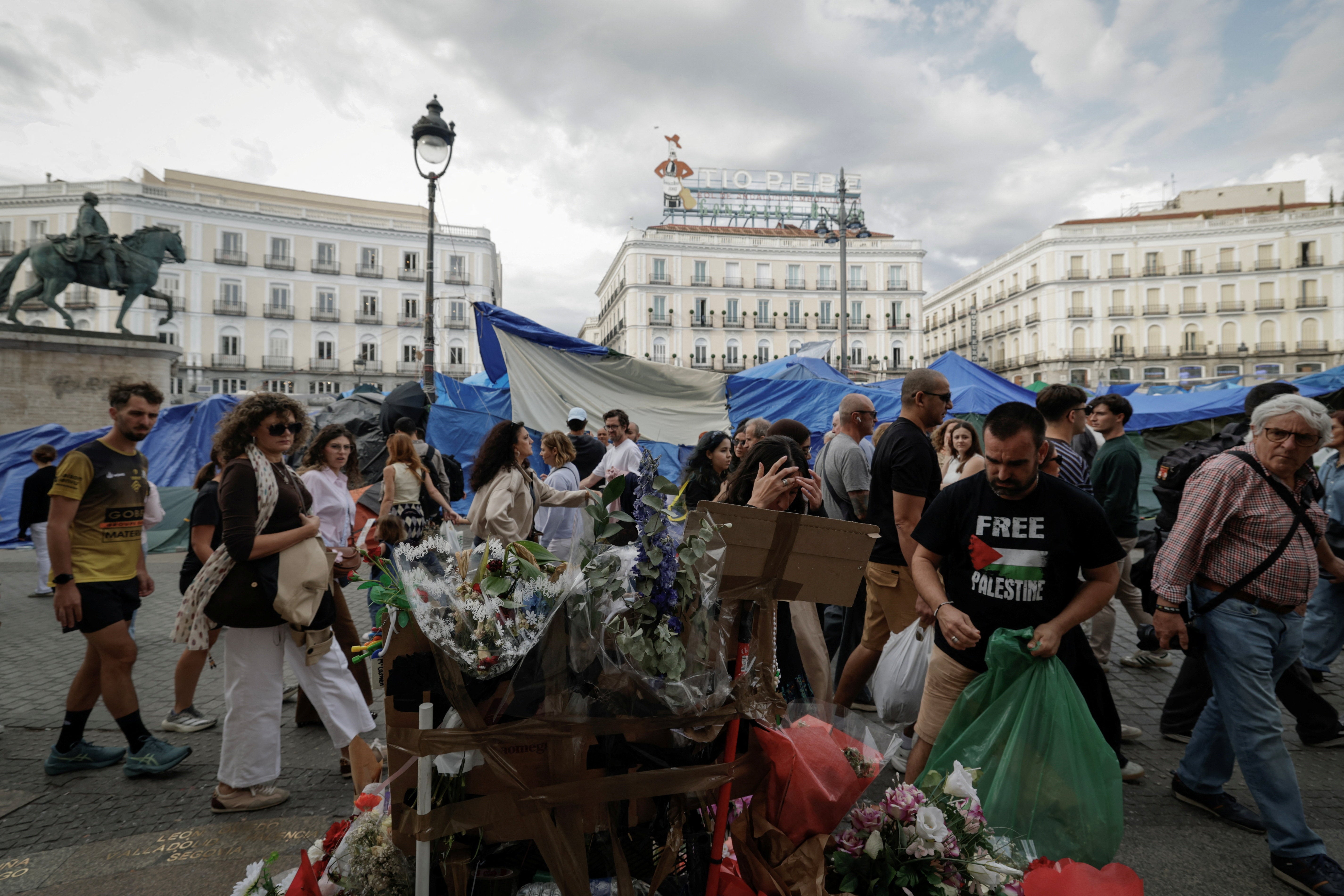 People walk past a makeshift memorial outside the Community of Madrid government building for the late Maricarmen, on Saturday