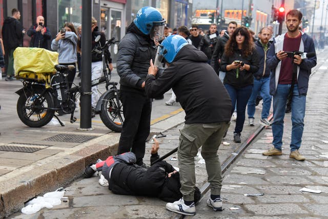 Italian police detain a protester during a protest over the state of public services and the rising cost of living in Milan