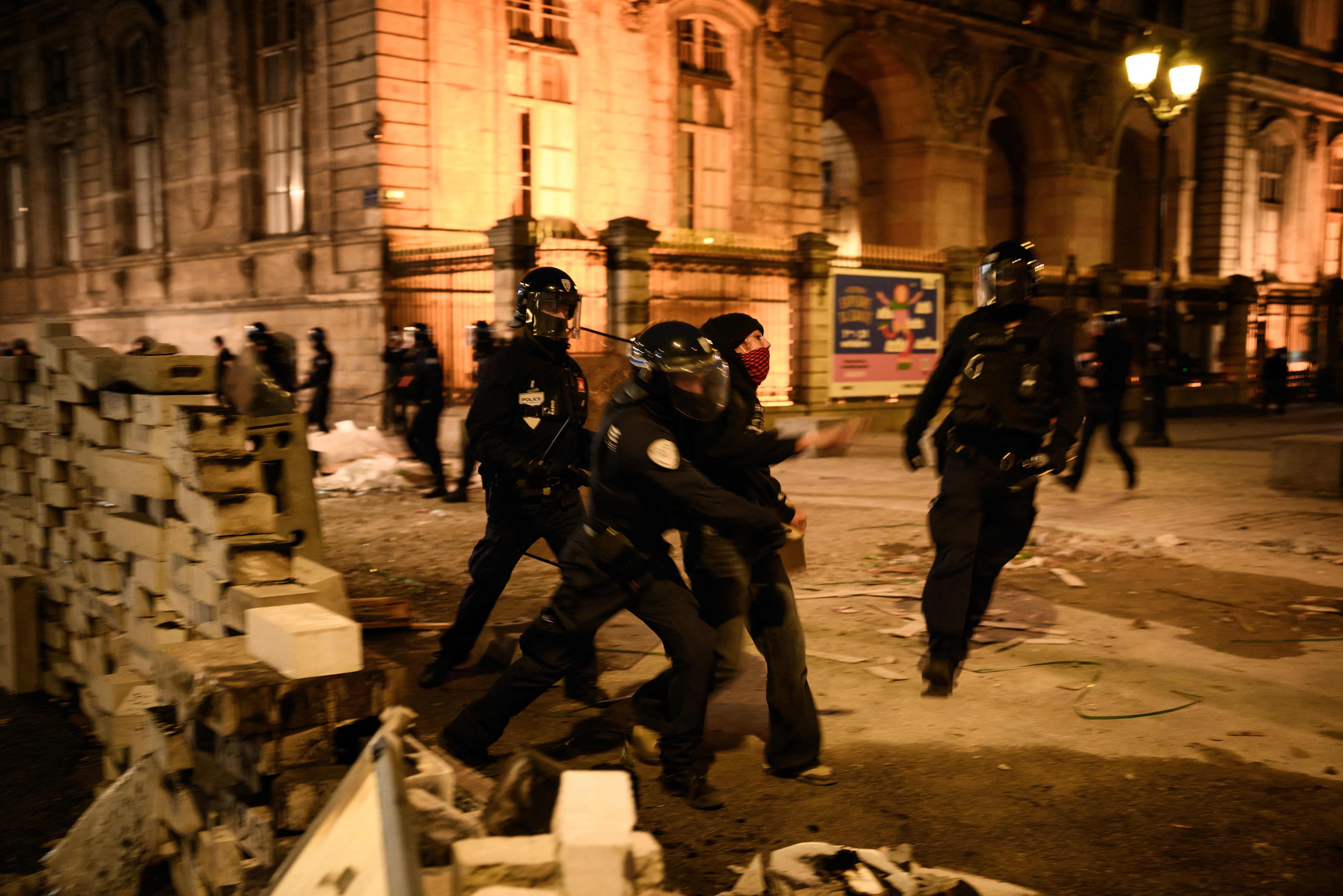 Police officers push a demonstrator at the Place de la Comedie in Lyon