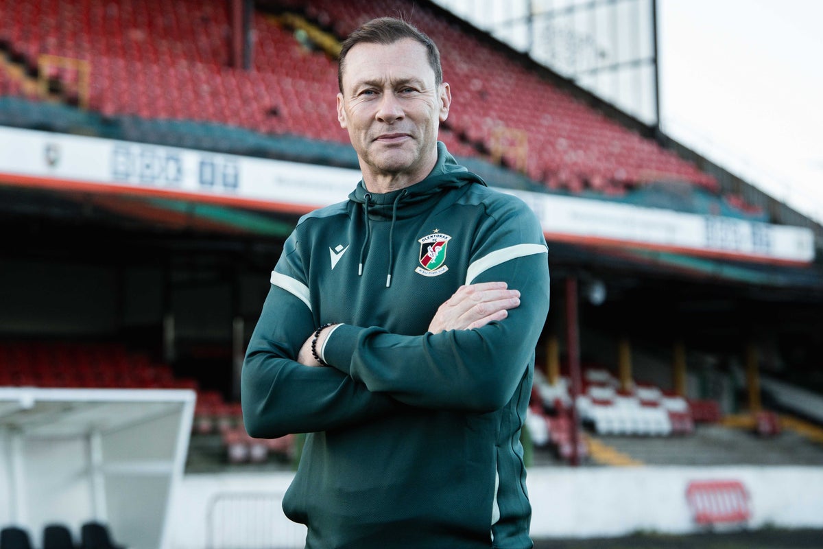 Duncan Ferguson, new manager of Glentoran, is presented at the Belfast club's ground with the team crest behind him.