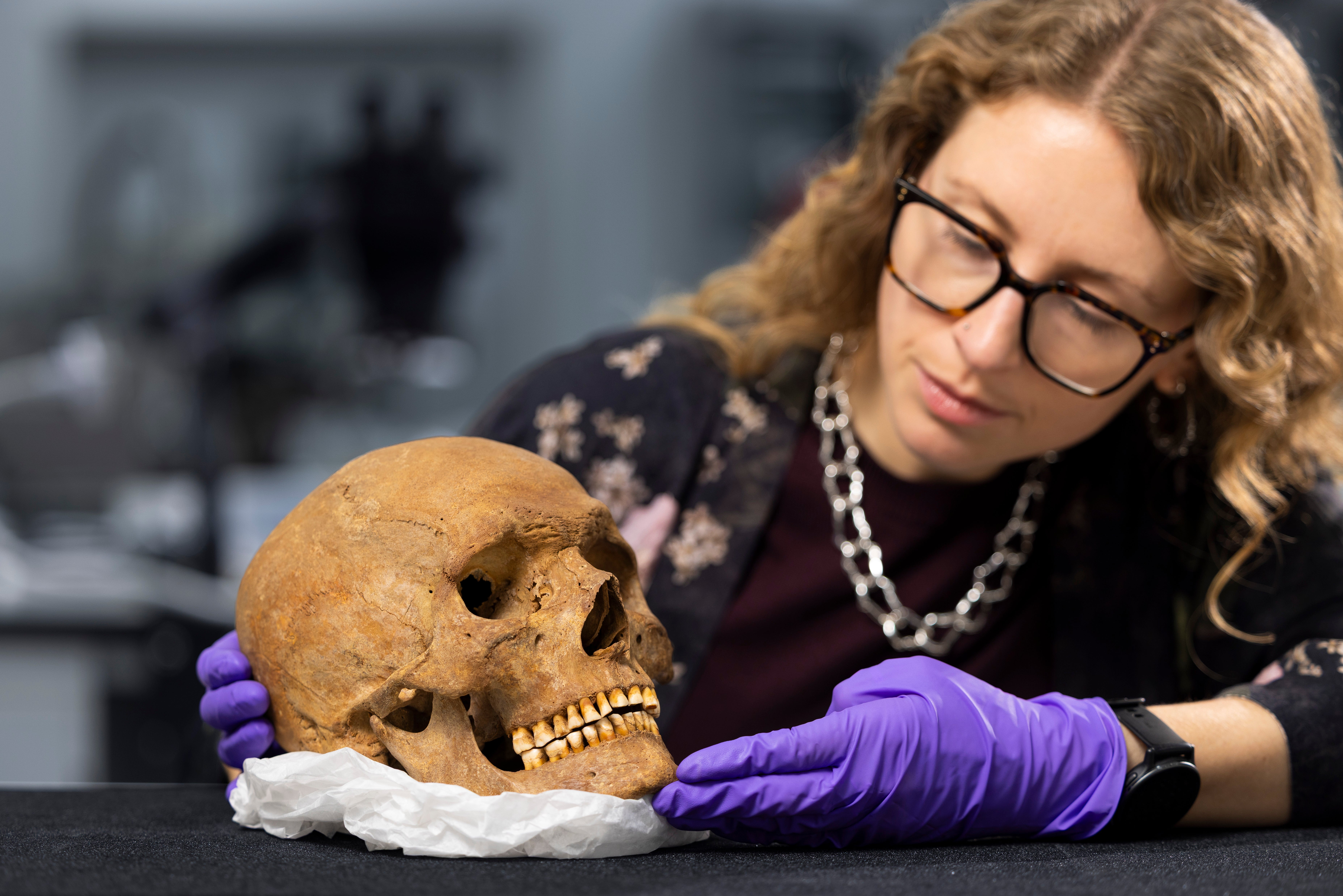 Dr Jess Thompson examining the skull of a man from Roman Scotland
