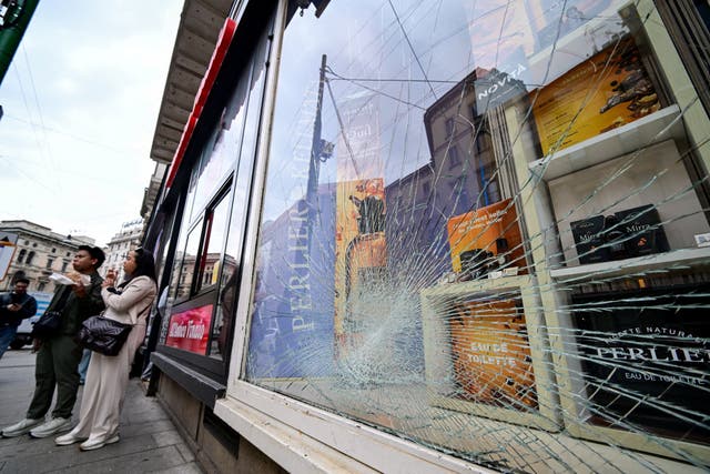 Milan’s luxury shops are boarding up amid fears of another rise in violence ( Reuters )