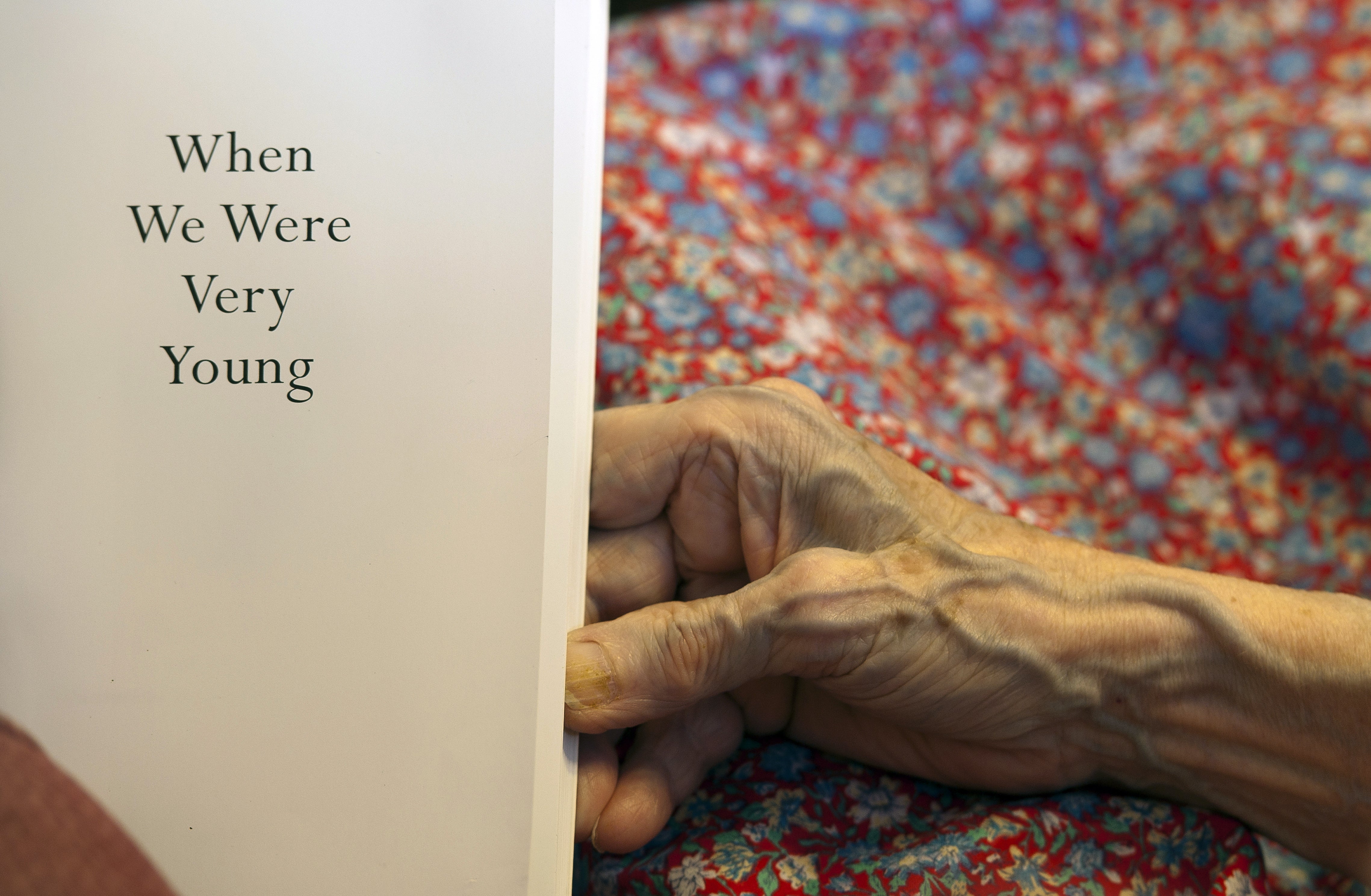 A volunteer reads to a resident suffering from dementia at a retirement home in Stratford upon Avon