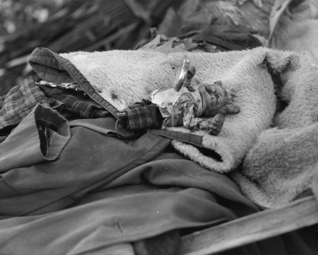 A child's toy on a heap of clothing that has been pulled from the rubble by rescue workers