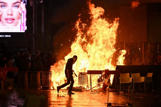 A barricade of cardboards and trash is set on fire as demonstrators clash with Police during an anti-government protest organized by the Italia in Piazza movement, at Piazza Duomo