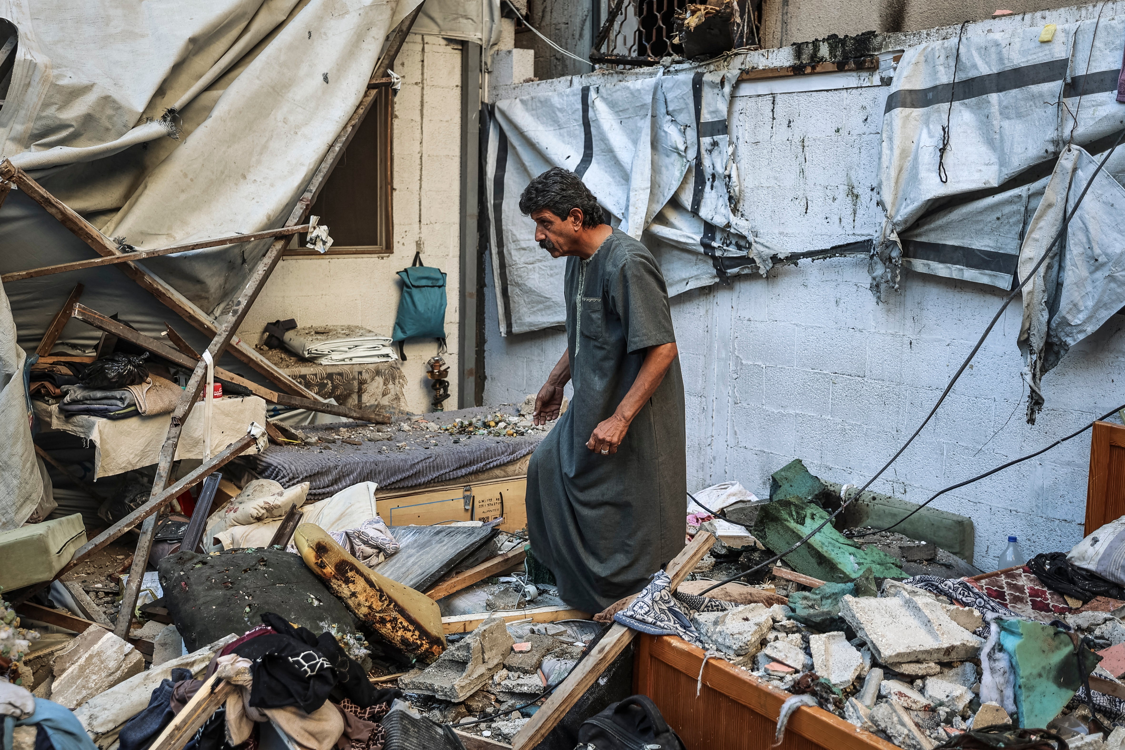 A man inspects the damage following an Israeli strike on a residential building that killed two people in Gaza City on October 20, 2026