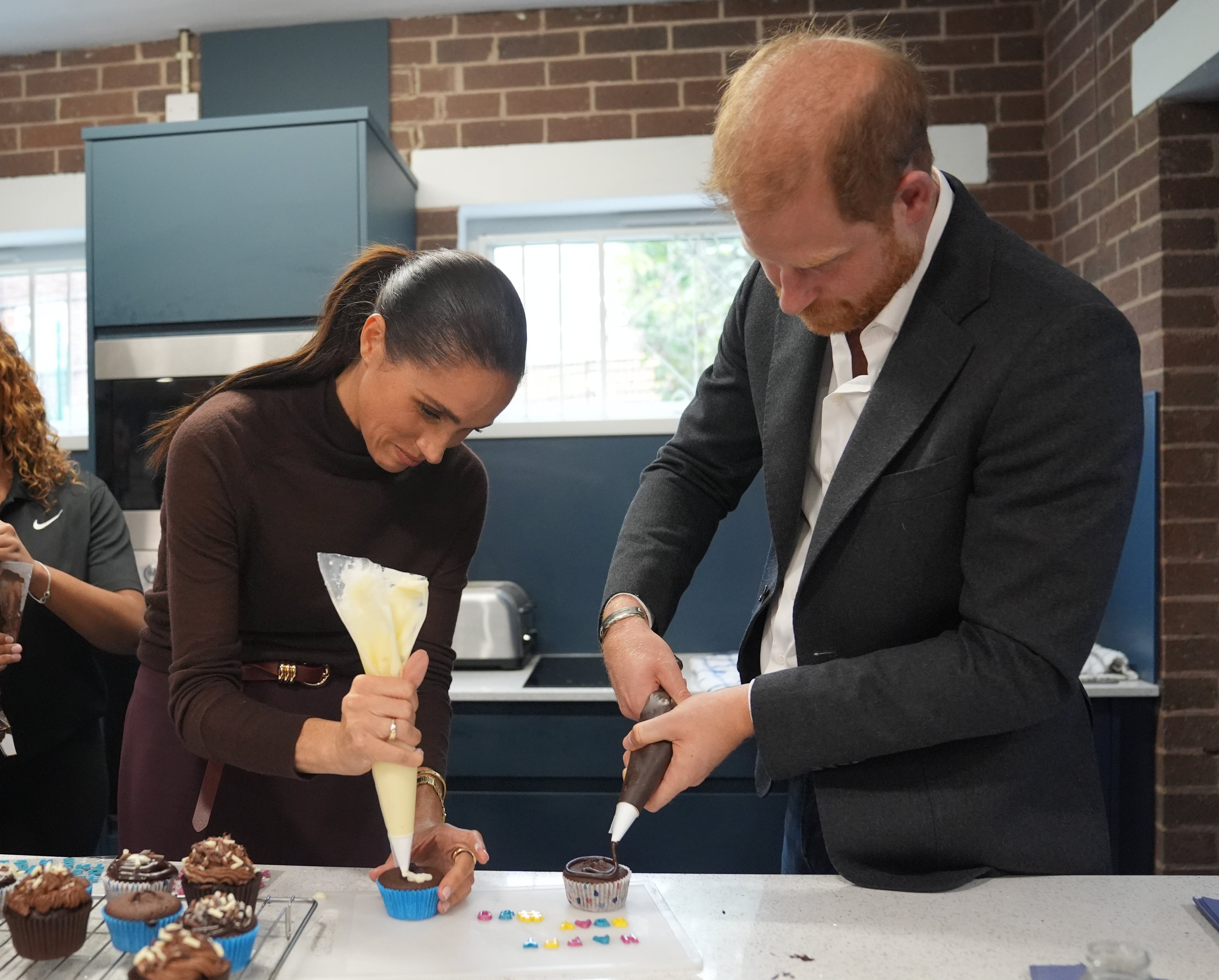 Meghan, duquesa de Sussex y el príncipe Harry, duque de Sussex, decoran cupcakes en Epic Partners durante su visita a Nottingham