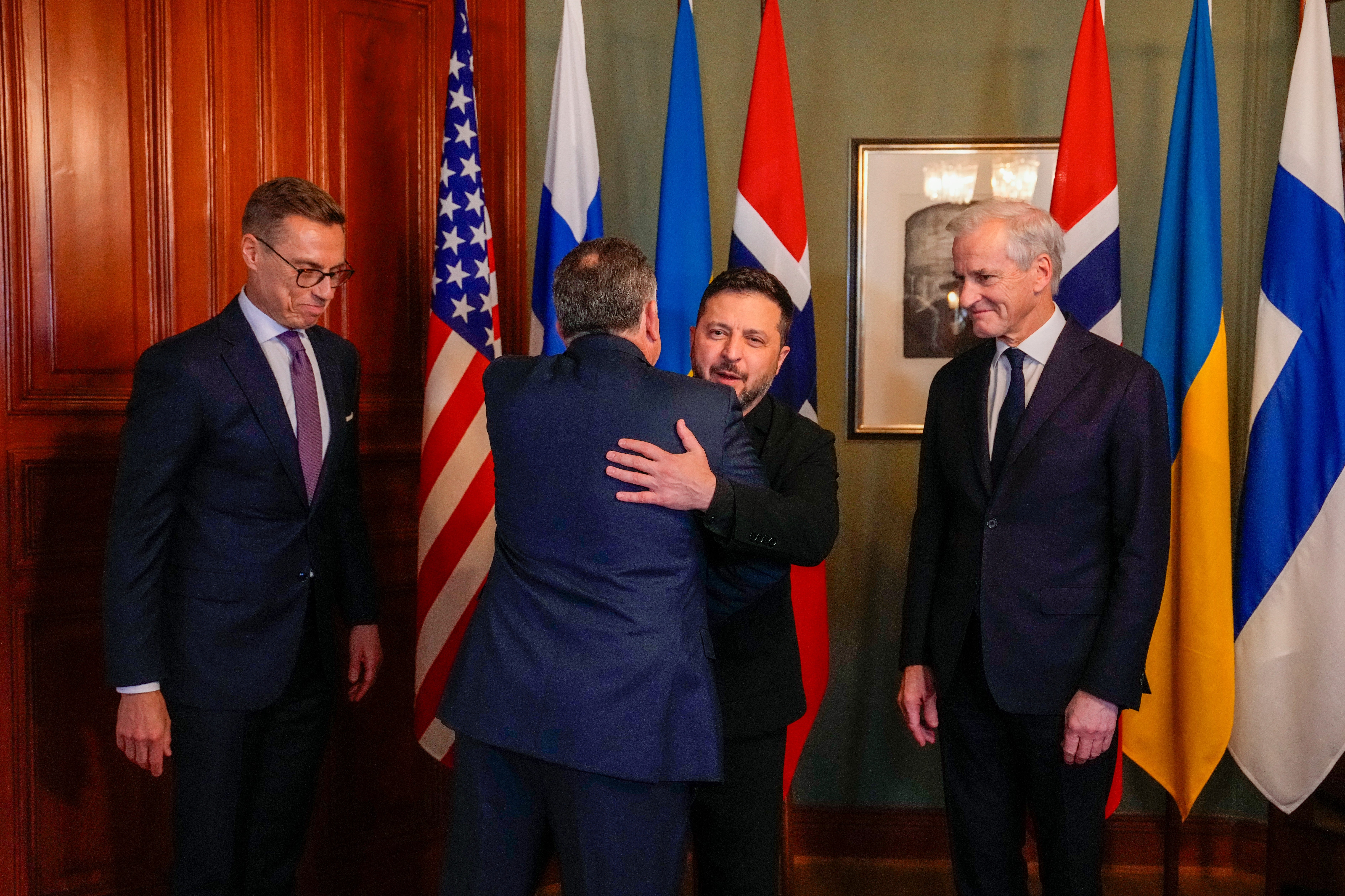 Ukrainian President Volodymyr Zelensky, centre, hugs US envoy Steve Witkoff despite growing tensions between Kyiv and Washington