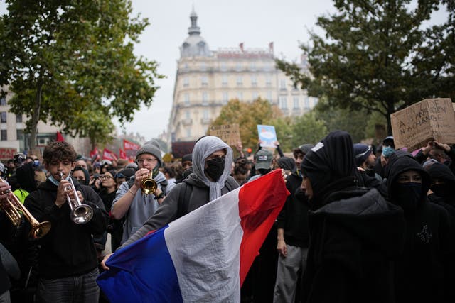A protesters holds a French flag during a demonstration against rising living costs, joining students' grievances, in Lyon, France, Saturday, Oct. 17, 2026