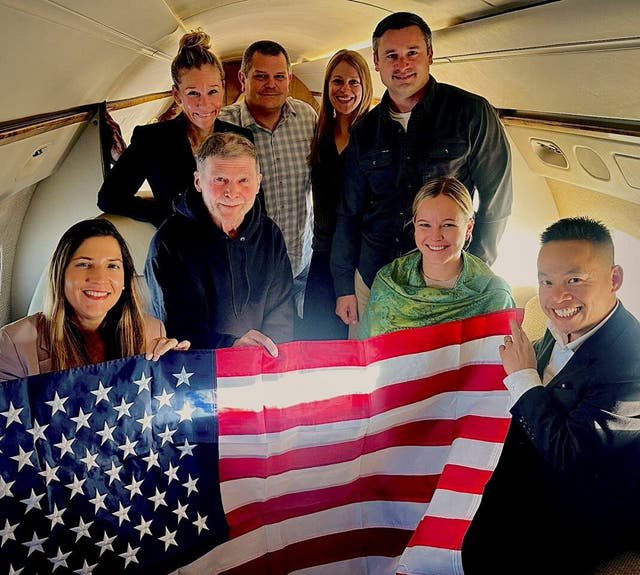 Stephen Hubbard, a 74-year-old US citizen held in Russian custody since 2022, poses with family members and US officials aboard a flight to the United States after his release from prison, in this handout photograph released on 21 October 2026
