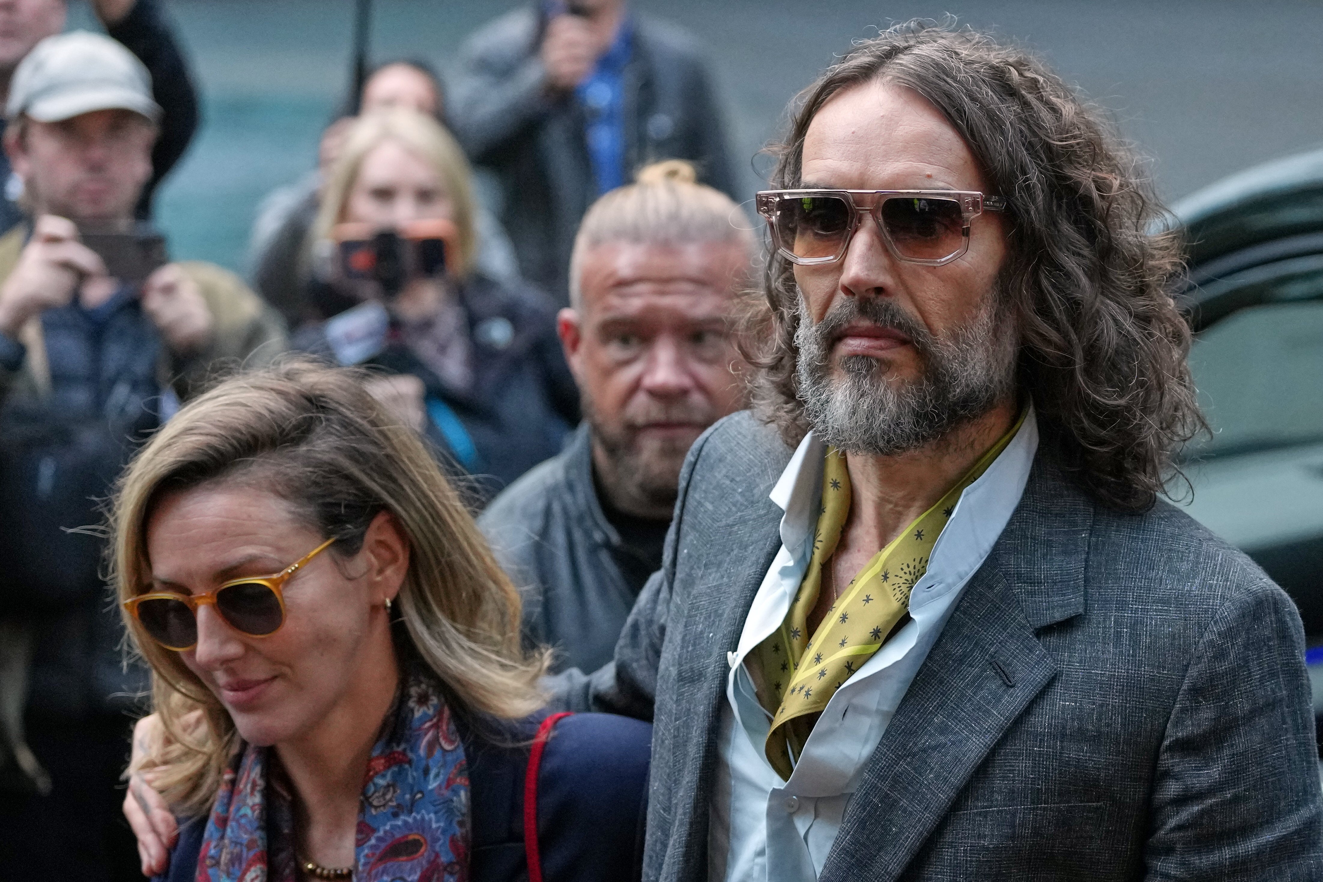 Comedian and actor Russell Brand, accompanied by his wife Laura Brand, arrives at Southwark Crown Court in London