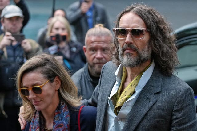 Comedian and actor Russell Brand, accompanied by his wife Laura Brand, arrives at Southwark Crown Court in London