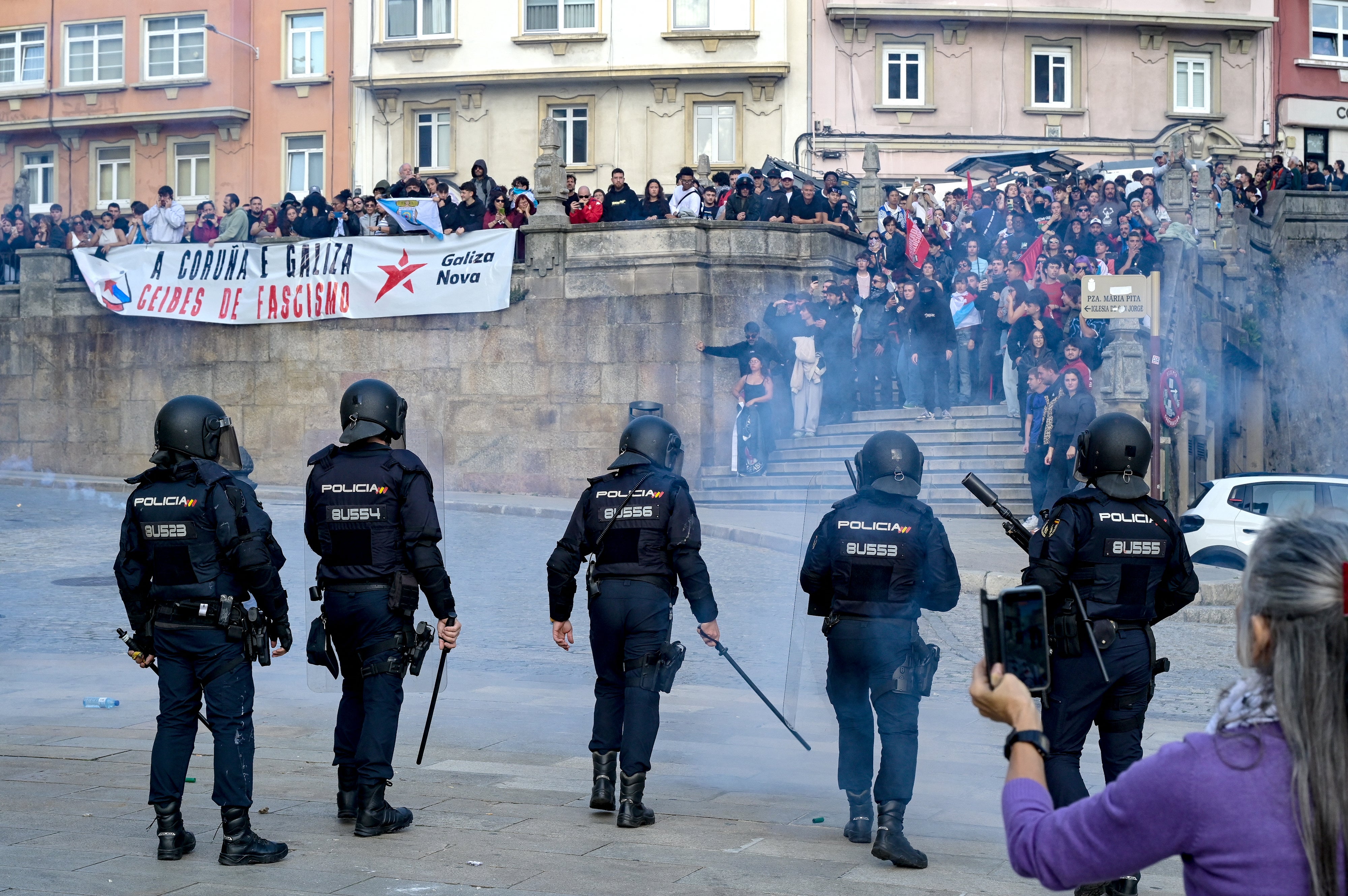 Police forces face protesters taking part in a demonstration against far-right during a meeting of Vox party's leader in Maria Pita square on Wednesday