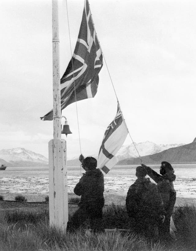 A Union Flag and white ensign being raised on South Georgia after the island's recapture by the British in May 1982