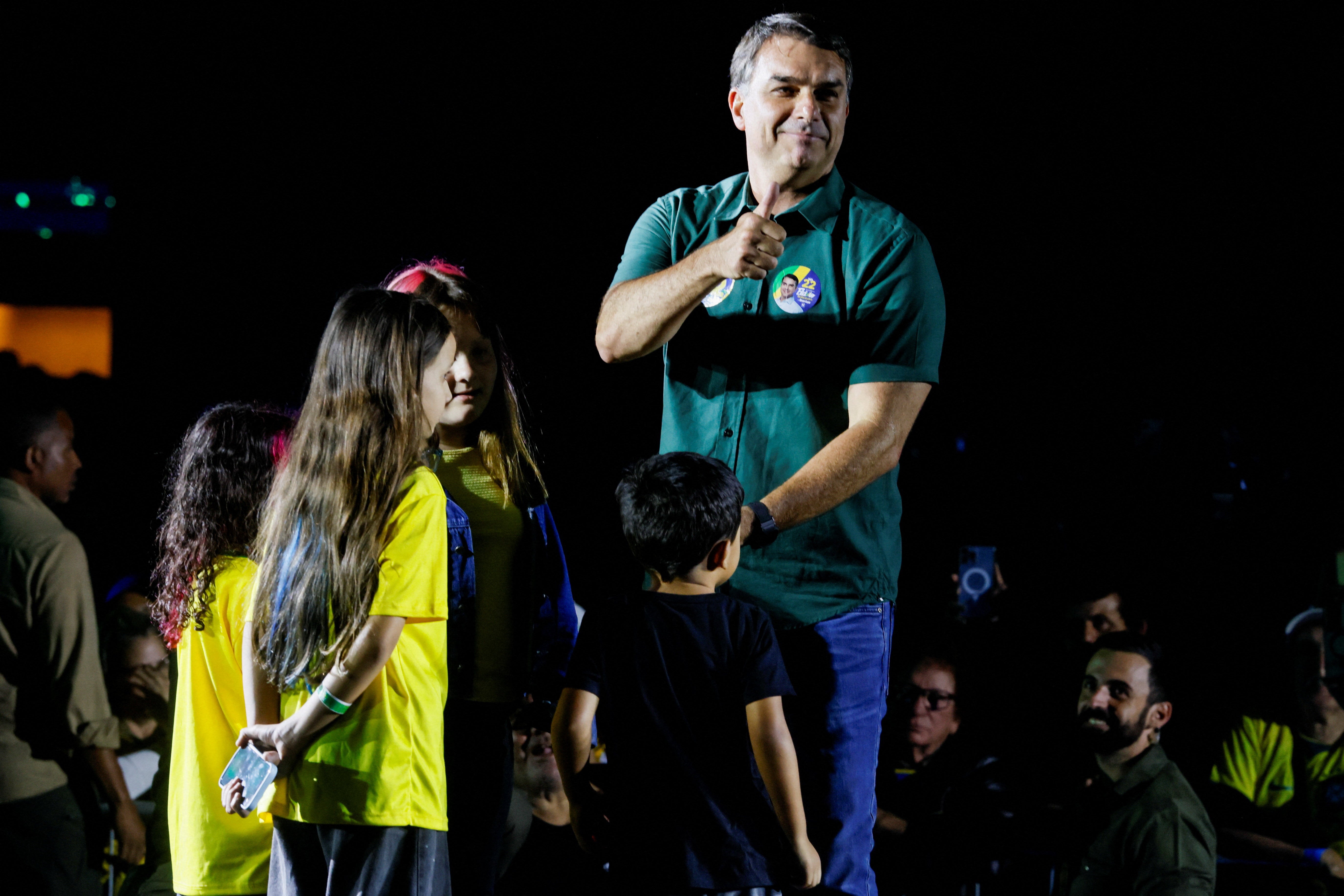 Presidential candidate Flavio Bolsonaro from the Liberal Party (PL) gestures on stage joined by children from the audience