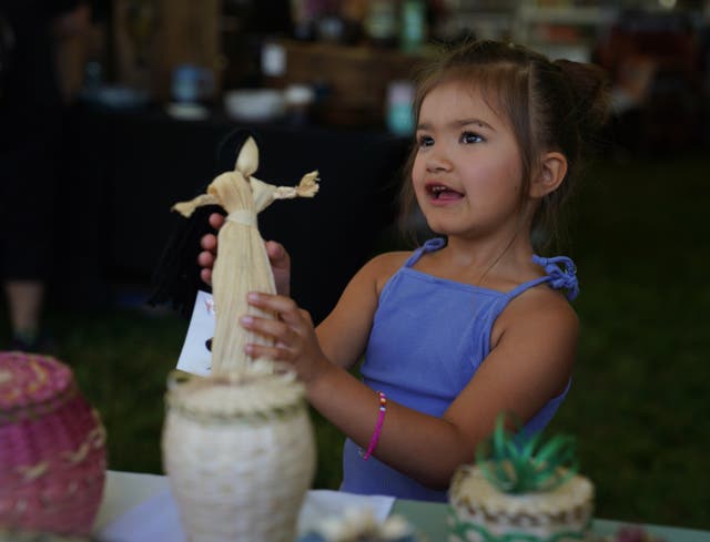 Lydia Soctomah's daughter holds a present gifted to her at the Abbe Museum's Dawnland Festival of Arts and Ideas held at the College of the Atlantic in Bar Harbor, Maine