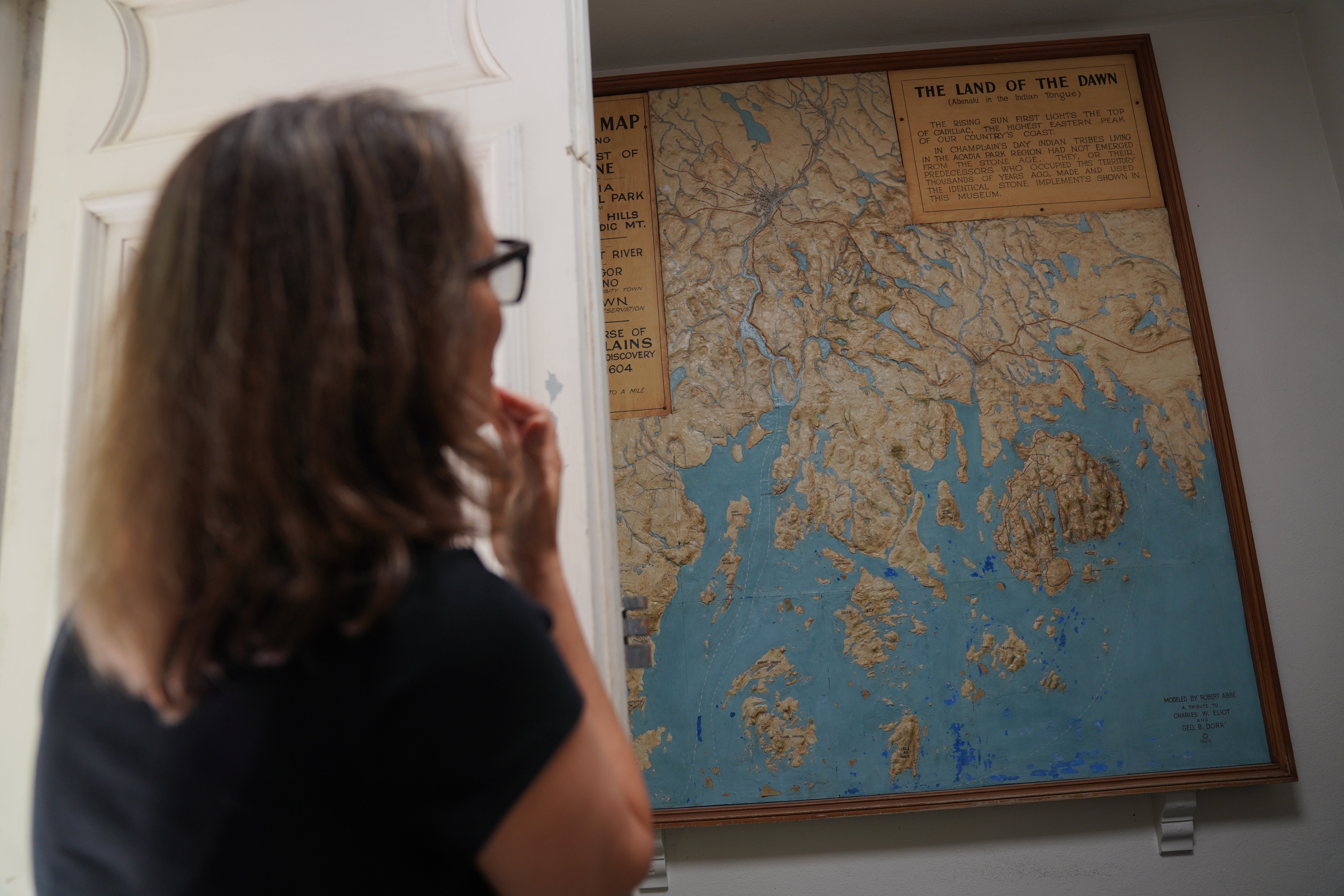 Abbe Museum Executive Director Betsy Richards, citizen of the Cherokee Nation, looks at an outdated map of Mount Desert Island in Maine, home to Acadia National Park, hanging in a small private museum location being renovated within the park, on Tuesday, July 1, 2026