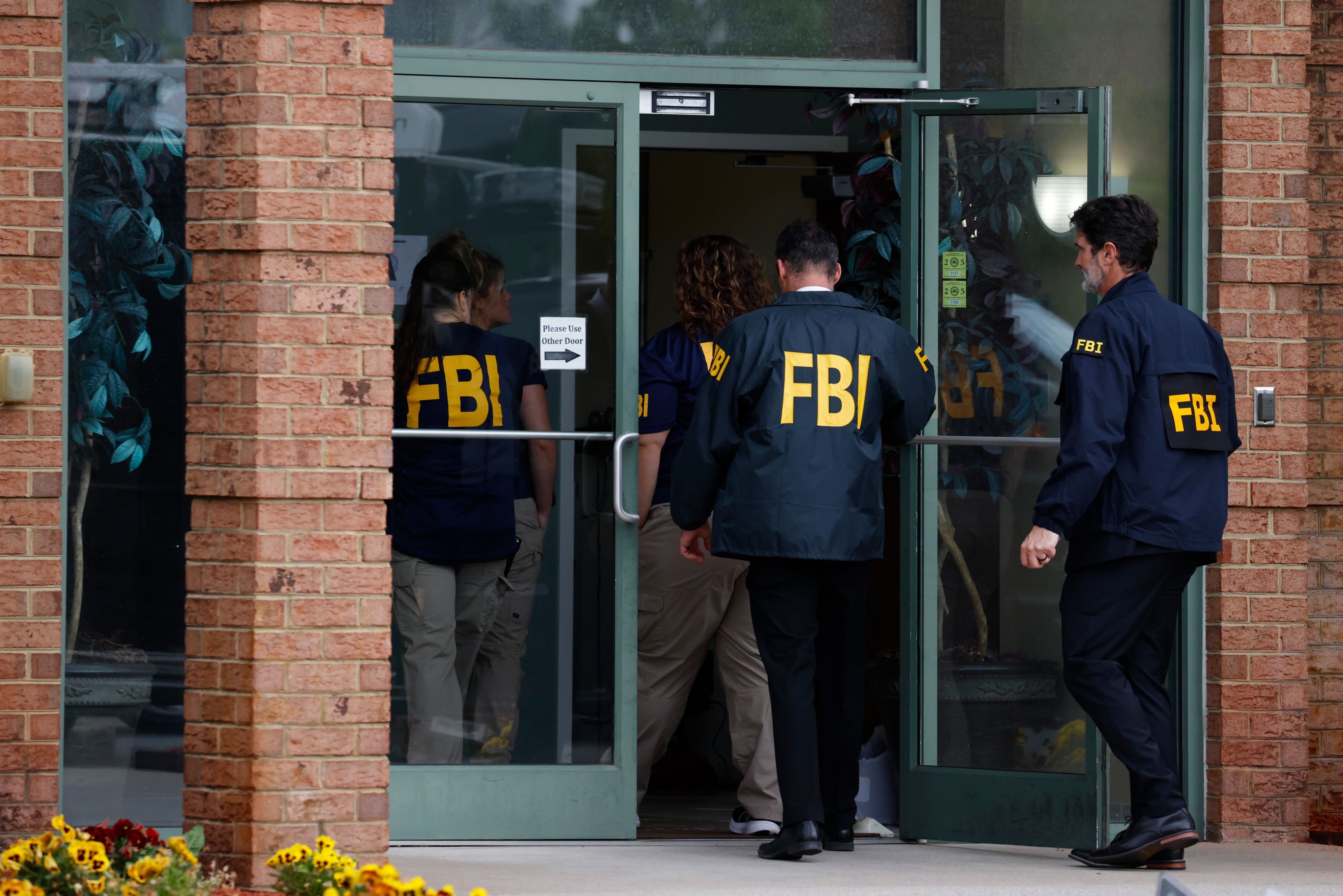 FBI personnel enter a building in Portsmouth, Va., May 6, 2026