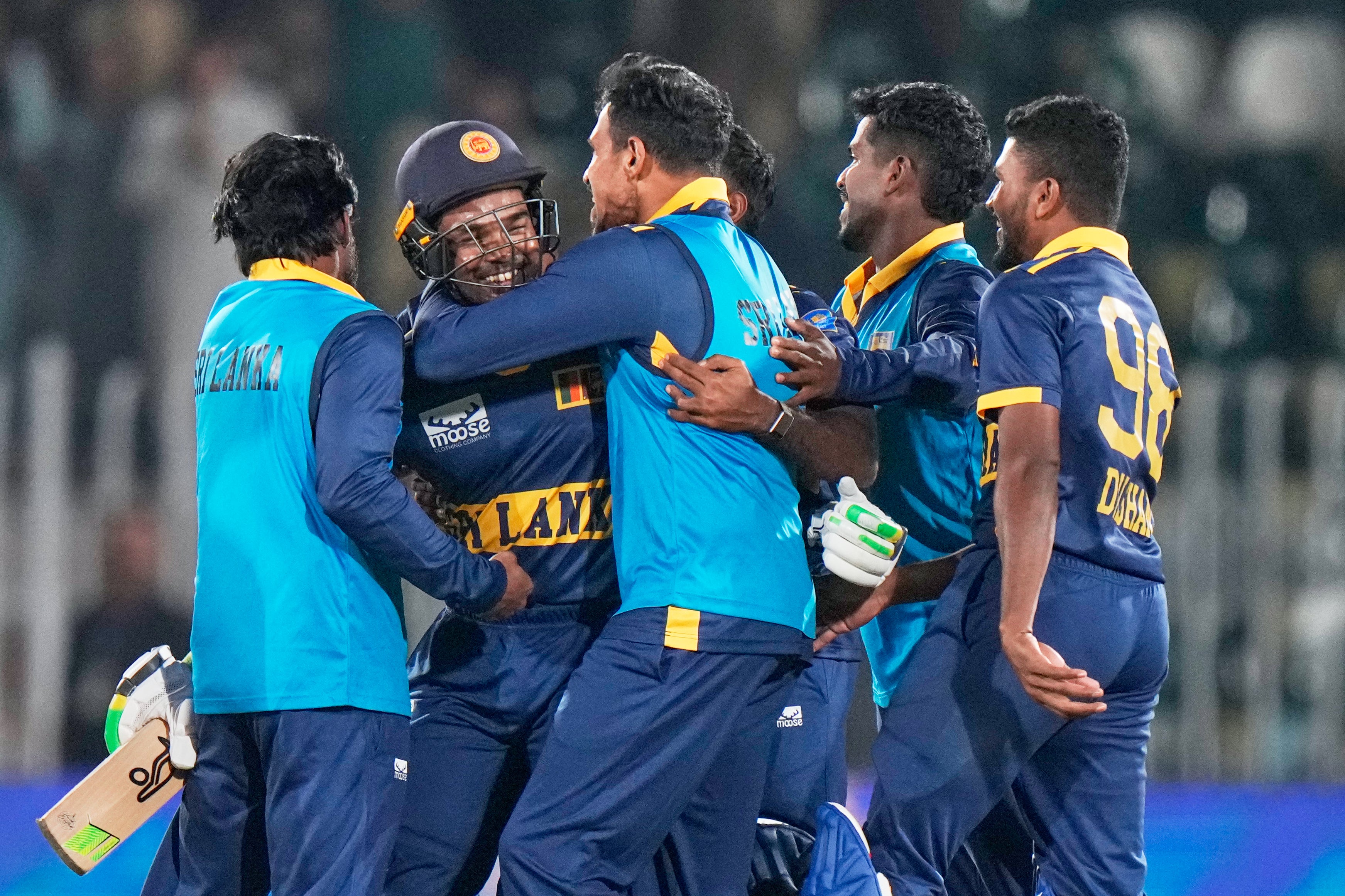 Janith Liyanage, second left, takes the congratulations after Sri Lanka’s stunning win (Anjum Naveed/PA)