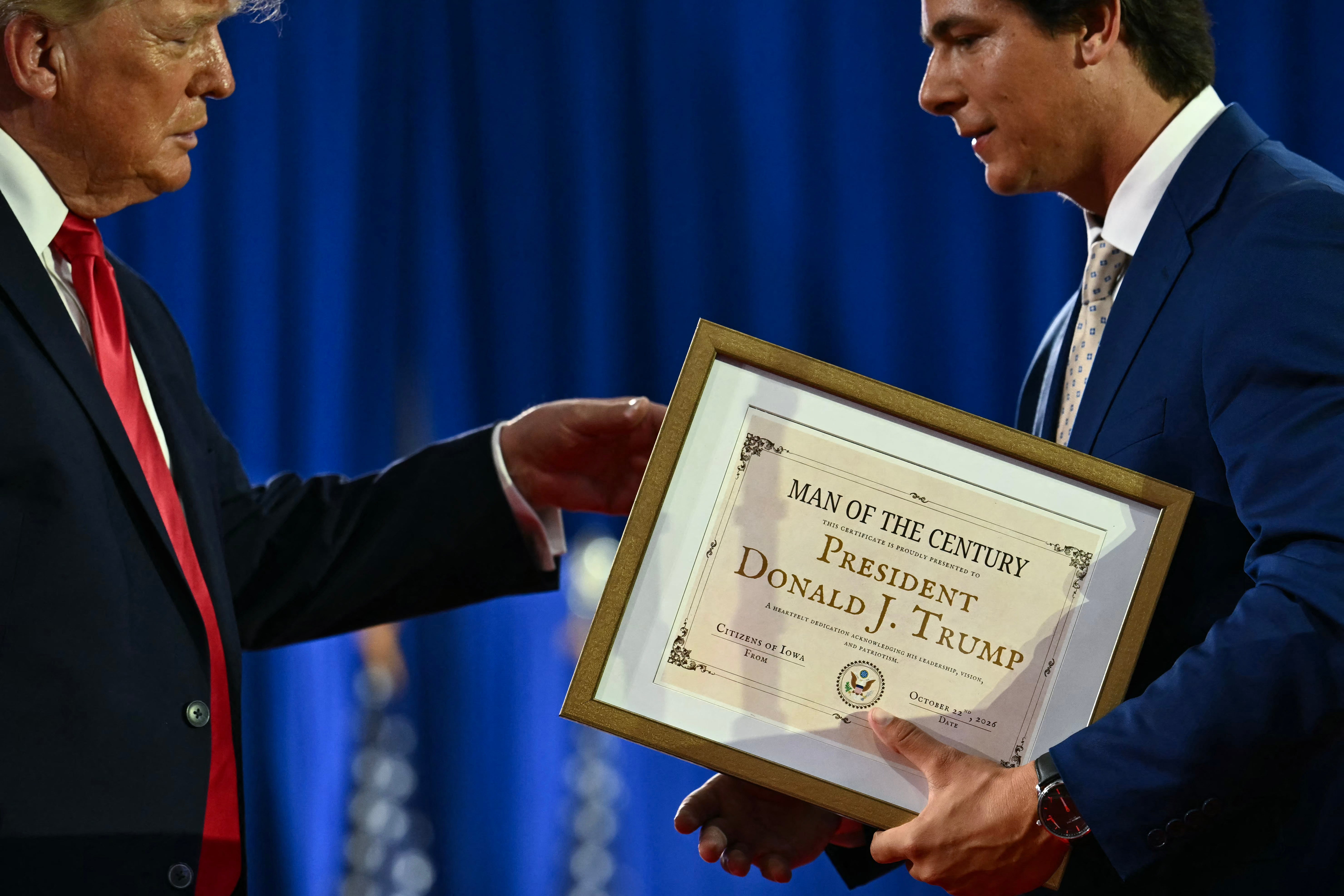 Trump receives his framed certificate from Mitchell