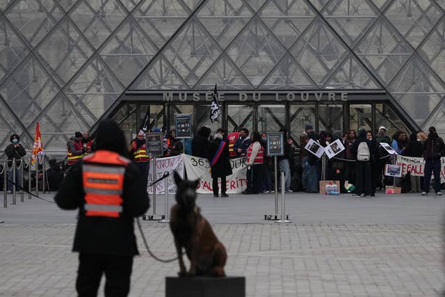 Workers block the entrance of the Louvre museum during a protest against rising living costs on 19 October