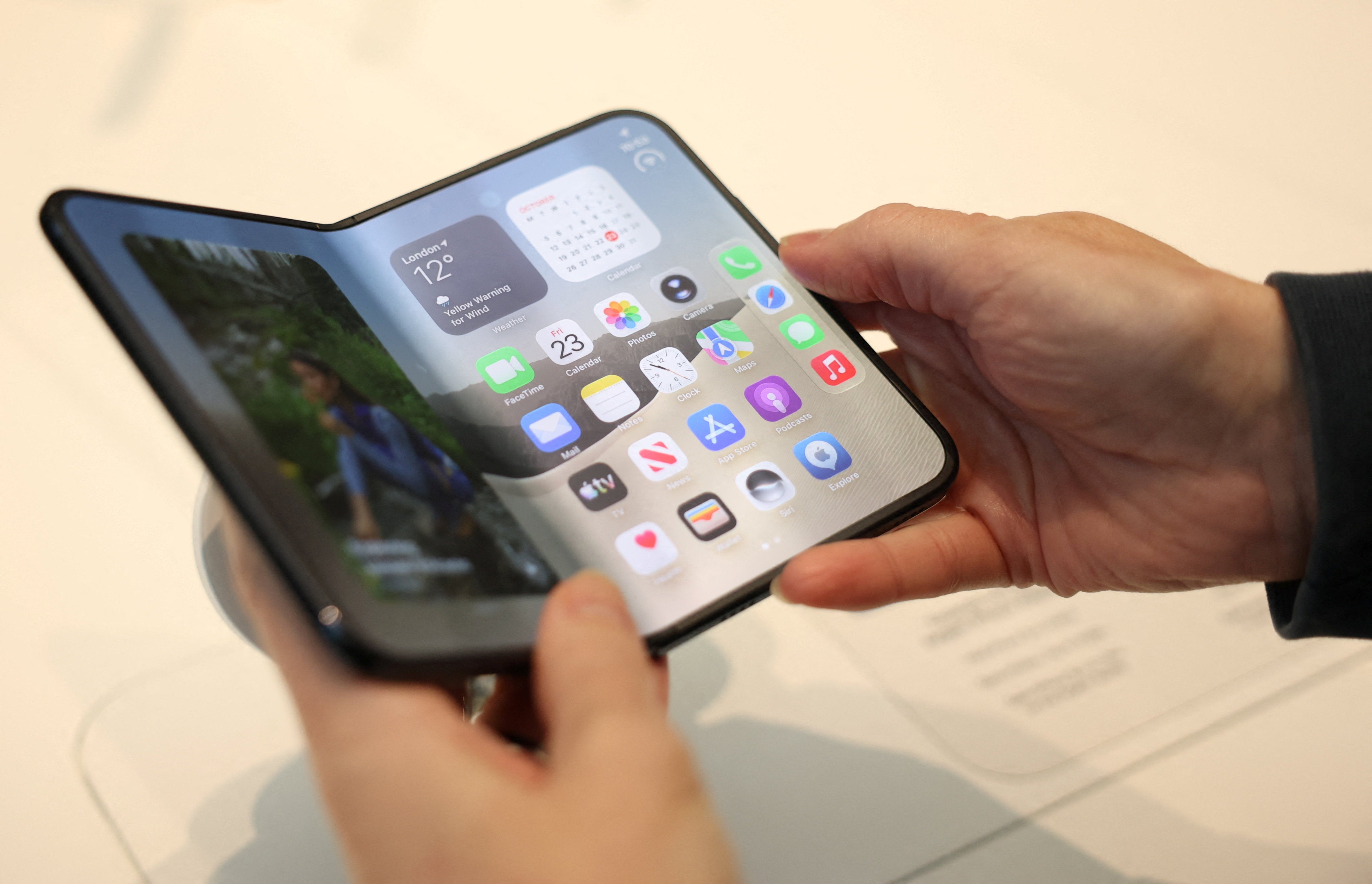 <p>A person uses the new foldable Apple iPhone Duo, on its launch day at an Apple store, in London, Britain, October 23, 2026</p>