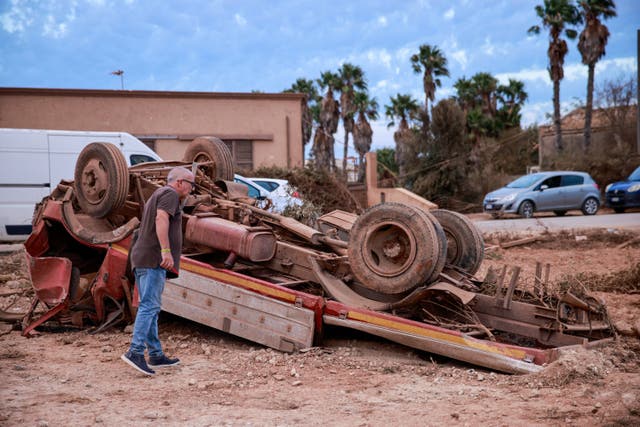 A man inspects an overturned truck after a tornado struck Marsala, a city on Sicily's west coast