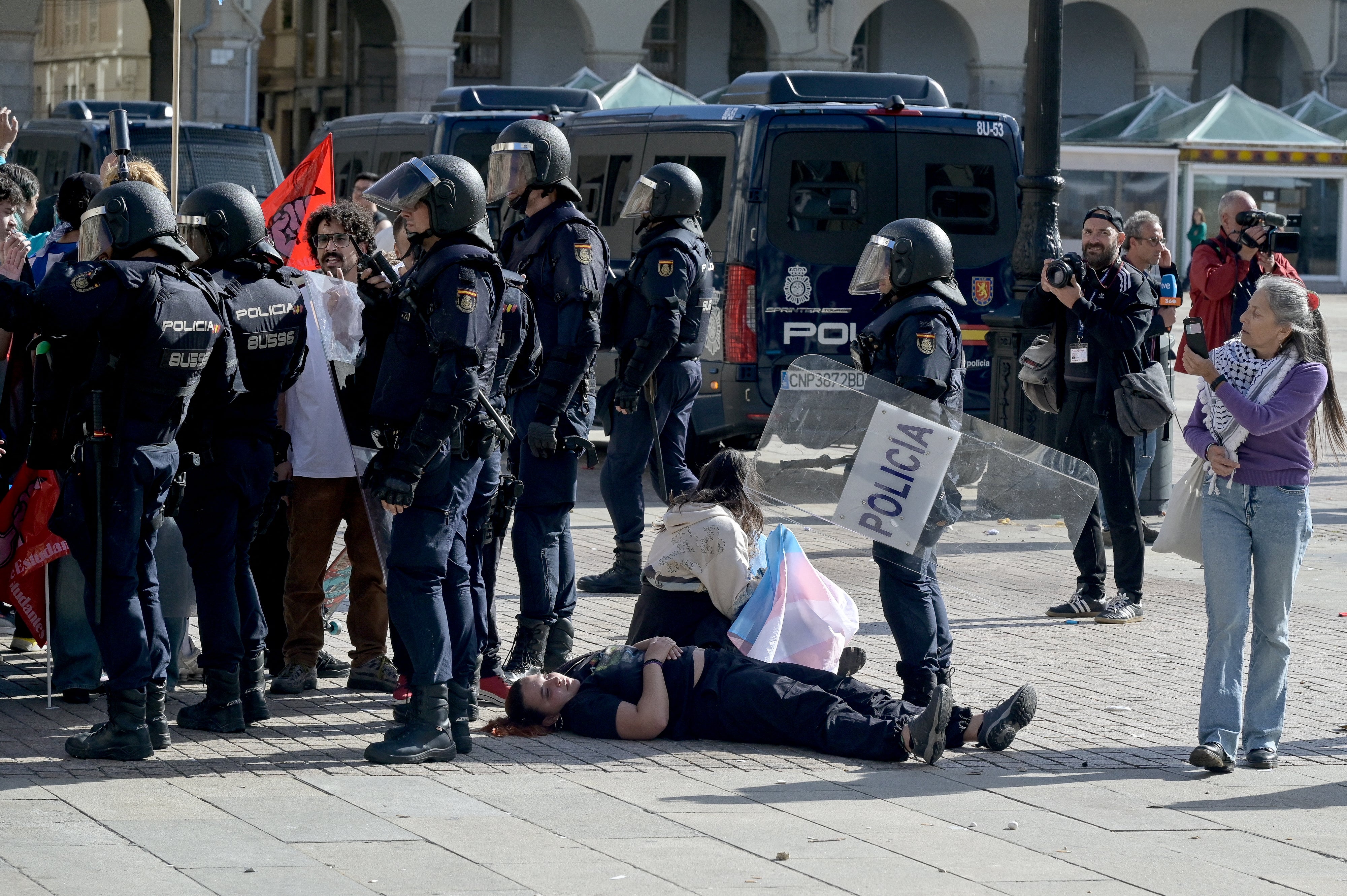Protesters lay on the ground next to police forces during a demonstration against far-right in A Coruña