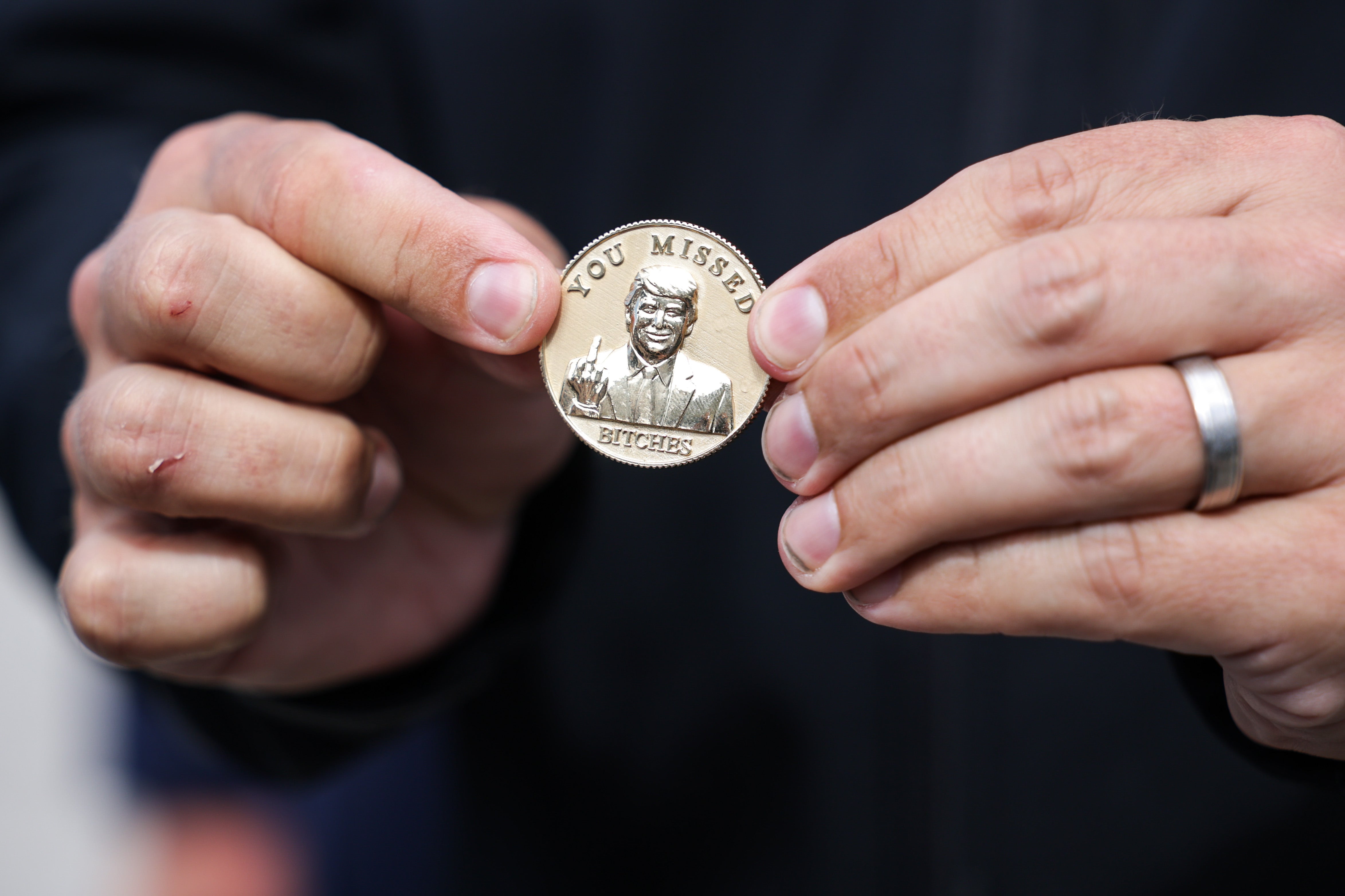 <p>Florida Gov. Ron DeSantis holds a coin that he gifted to President Donald Trump on Friday</p>